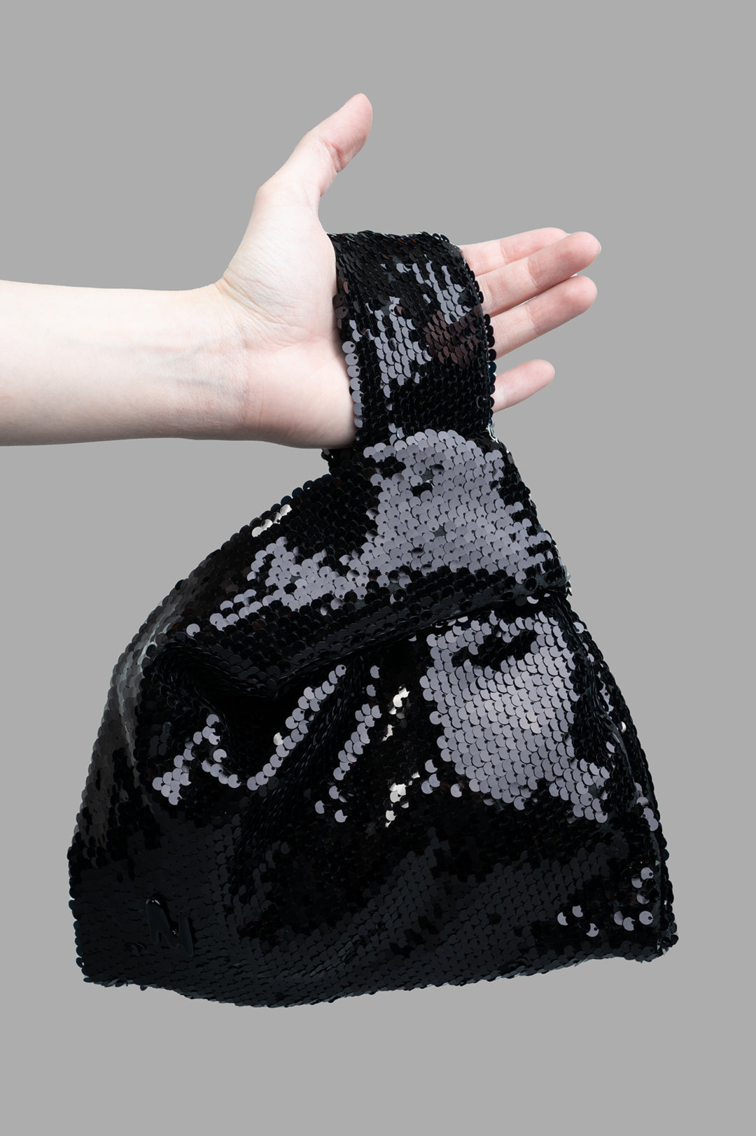 MSGM Black Paillettes Bag held in a hand, showcasing its shimmering sequins and stylish design. Perfect for any occasion.