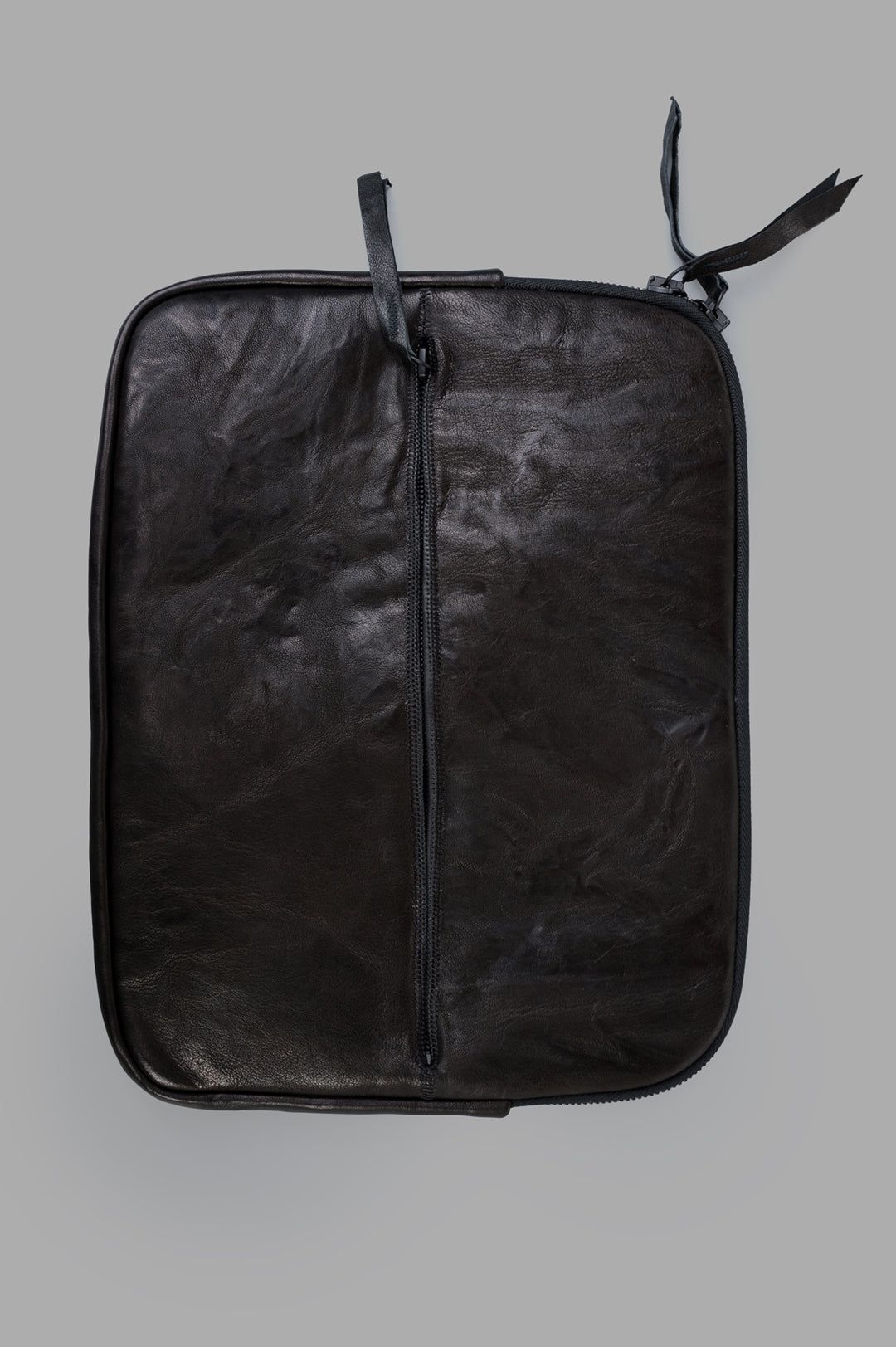Isaac Sellam Leather Laptop Pouch in black, showcasing double-opening zip and textured, premium leather material.