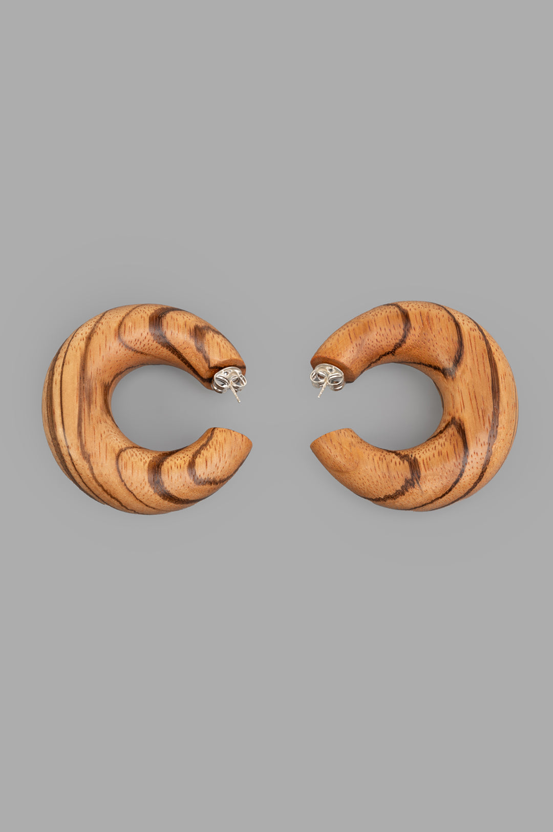 Monies Orbis Pin Earrings, front view, showcasing bold, wooden crescents in brown with unique natural texture.
