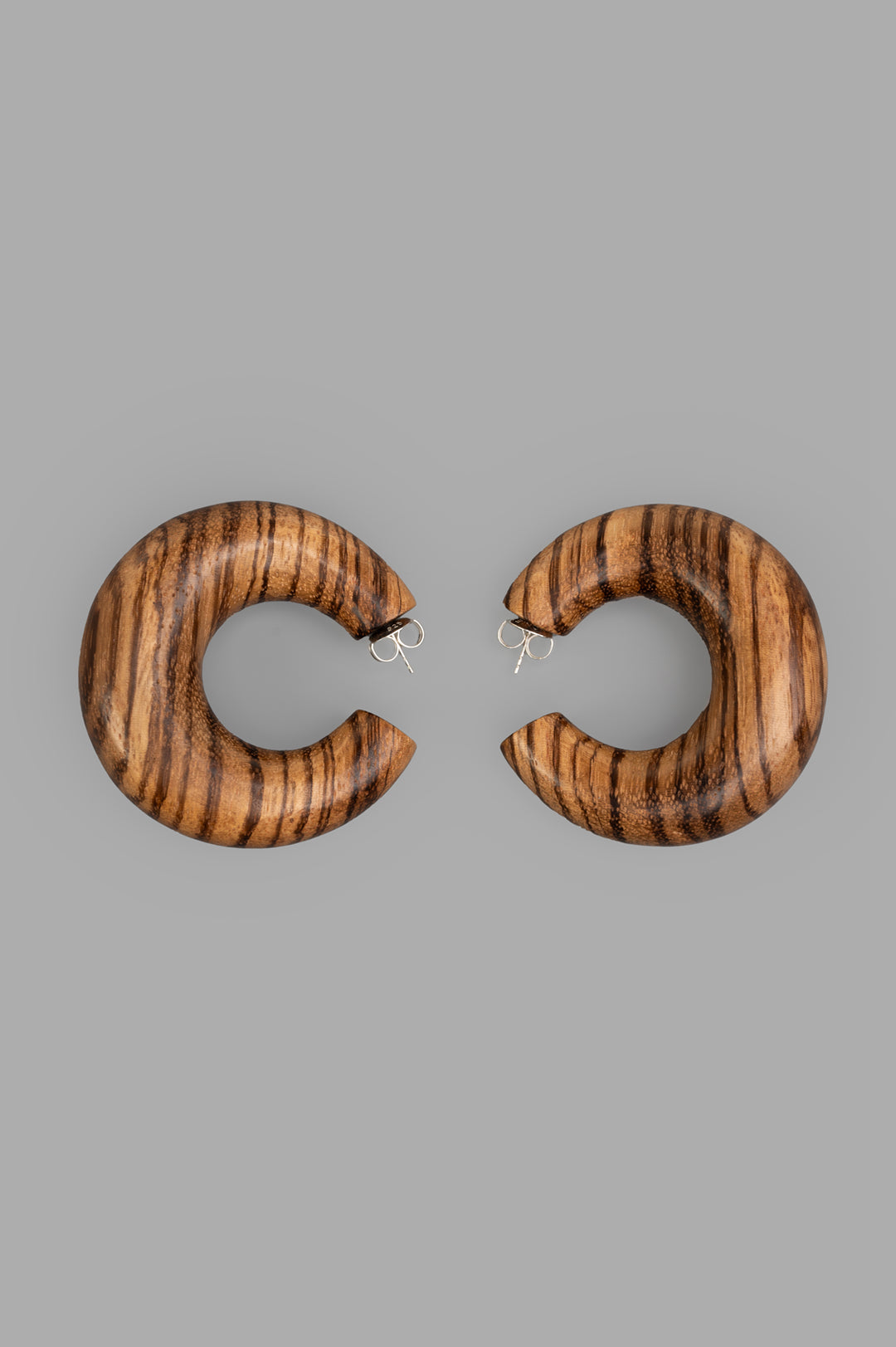 Monies Orbis Pin Striped Earrings, front view featuring bold, striped brown wood crescent design against gray background.