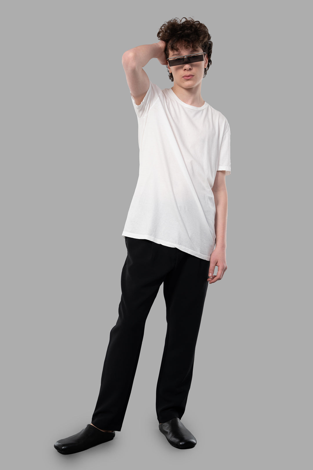 MD 75 Cotton T-shirt in white, modeled front view, showcasing its minimalist design and architectural silhouette.