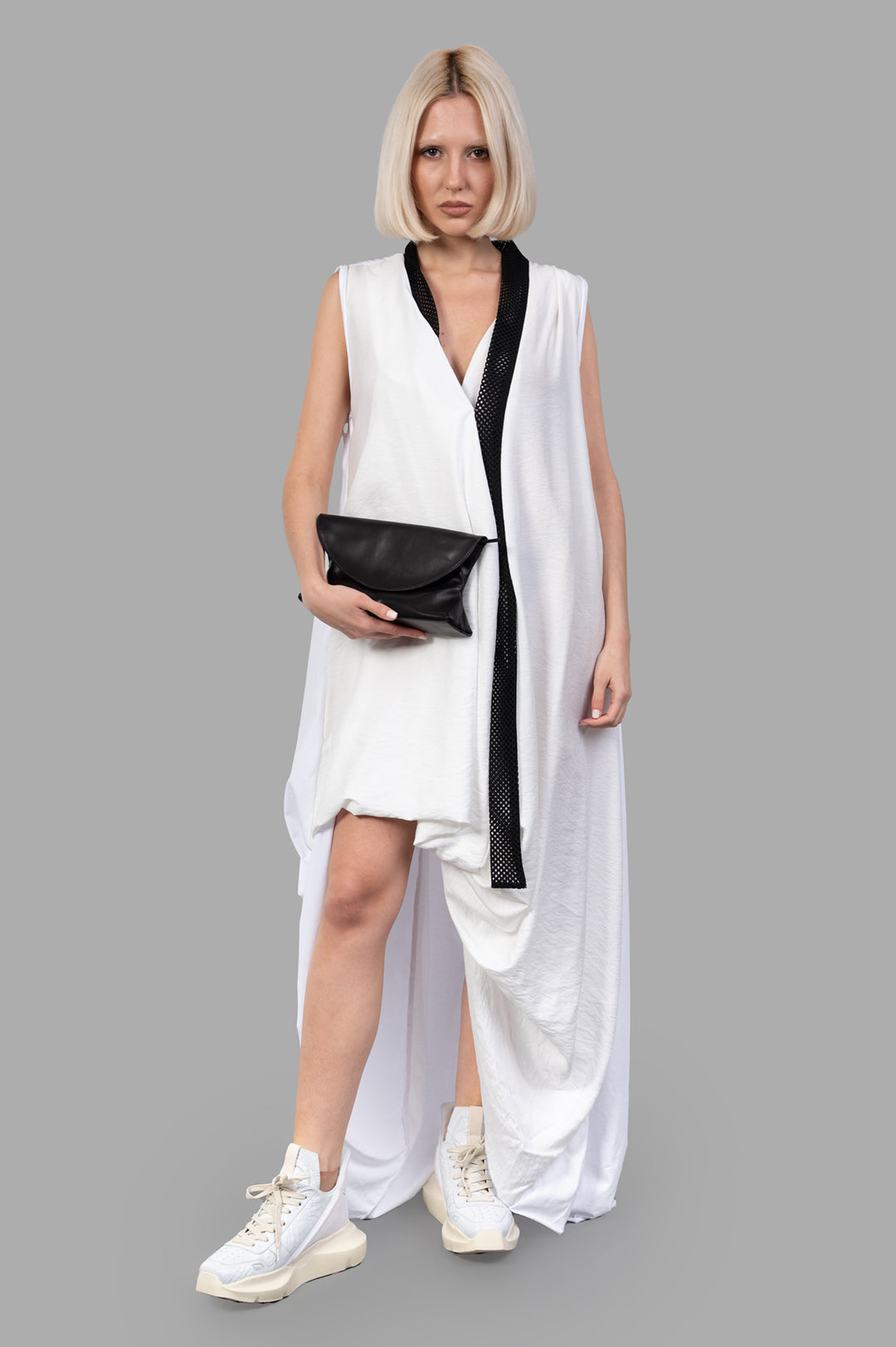 Giovanni Cavagna Asymmetric Dress, front view on model, features a black accent and is paired with white sneakers.
