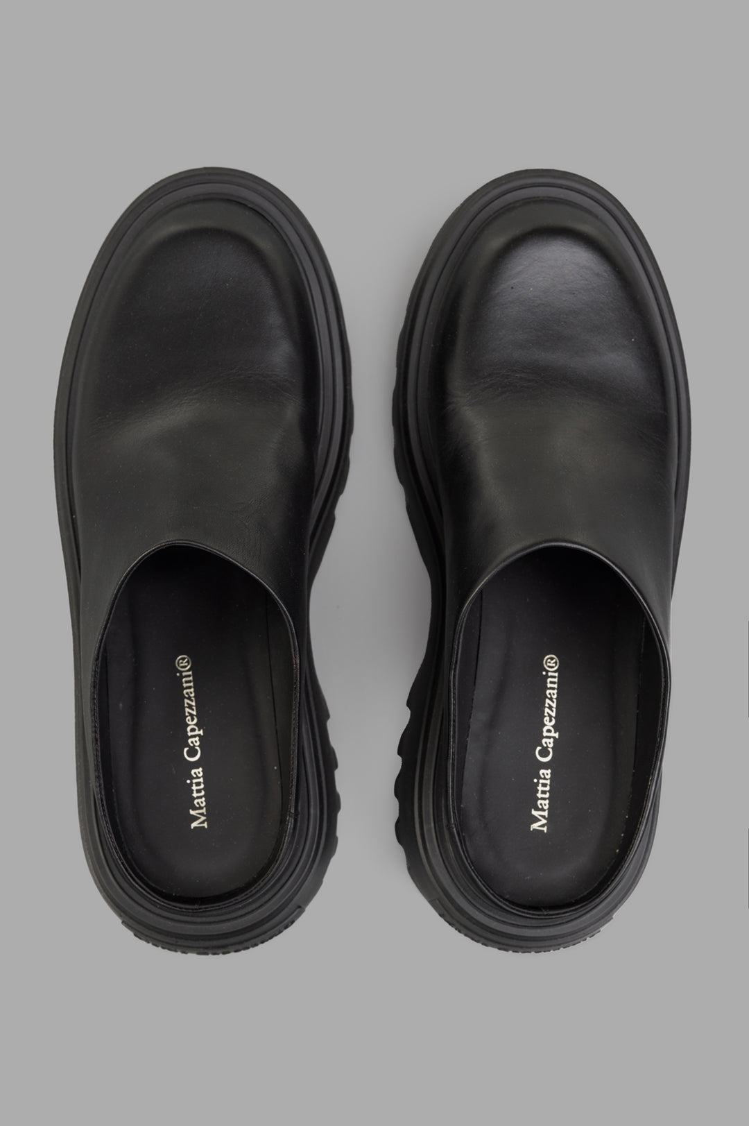 Mattia Capezzani Leather Mules in black, showcasing a sleek design and smooth leather texture from a top view.