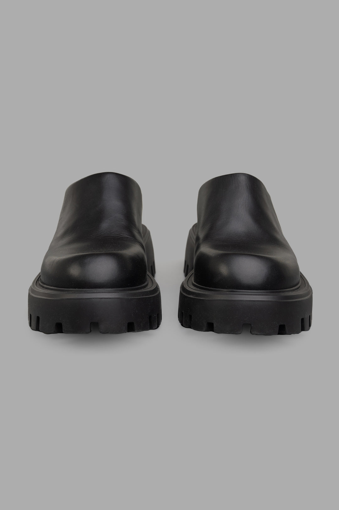 Mattia Capezzani Leather Mules featuring a sleek design and durable black leather, viewed from the front with chunky soles.