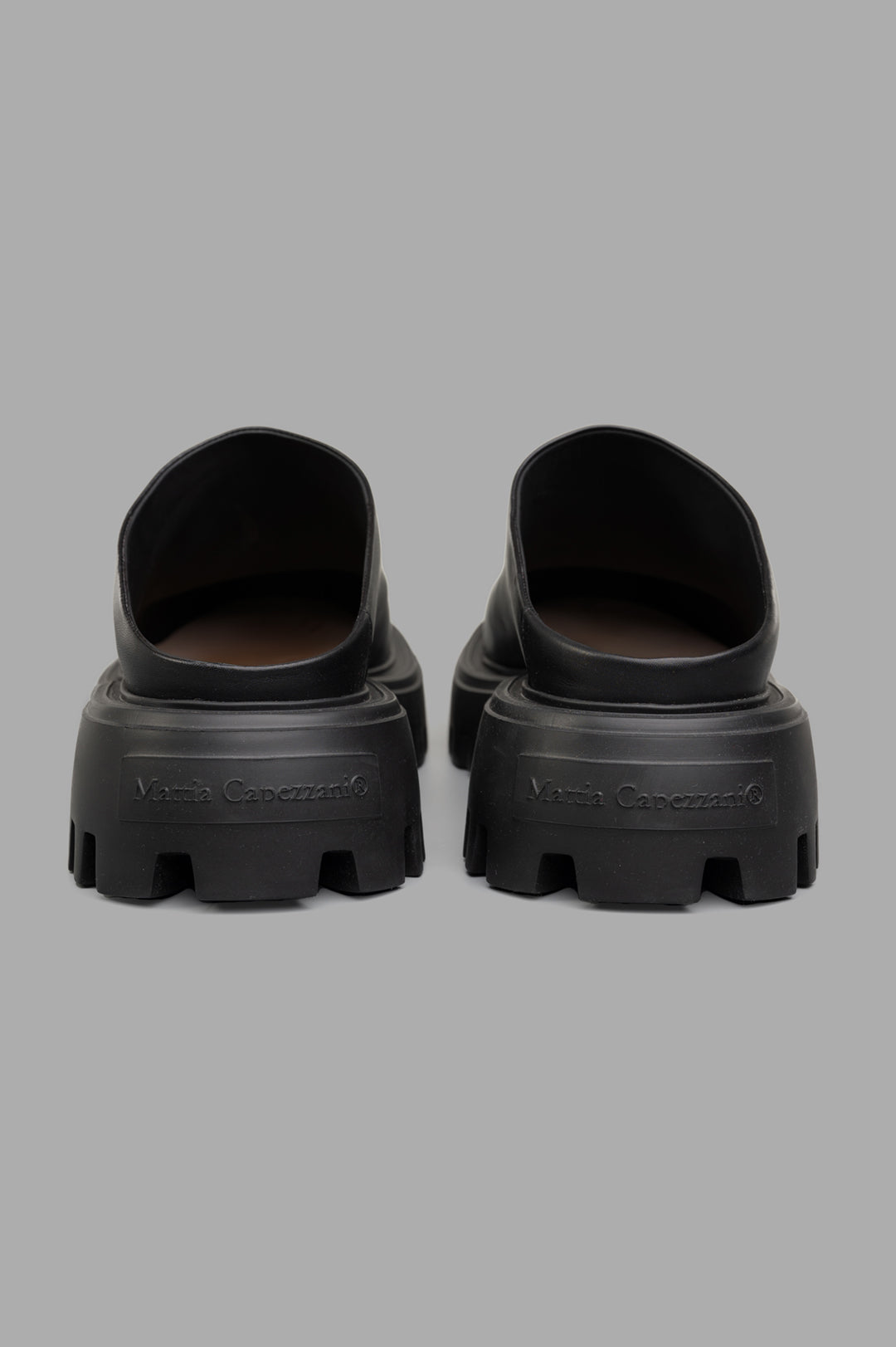 Mattia Capezzani Leather Mules in black, showcasing the rear view with sturdy soles and handcrafted leather detailing.