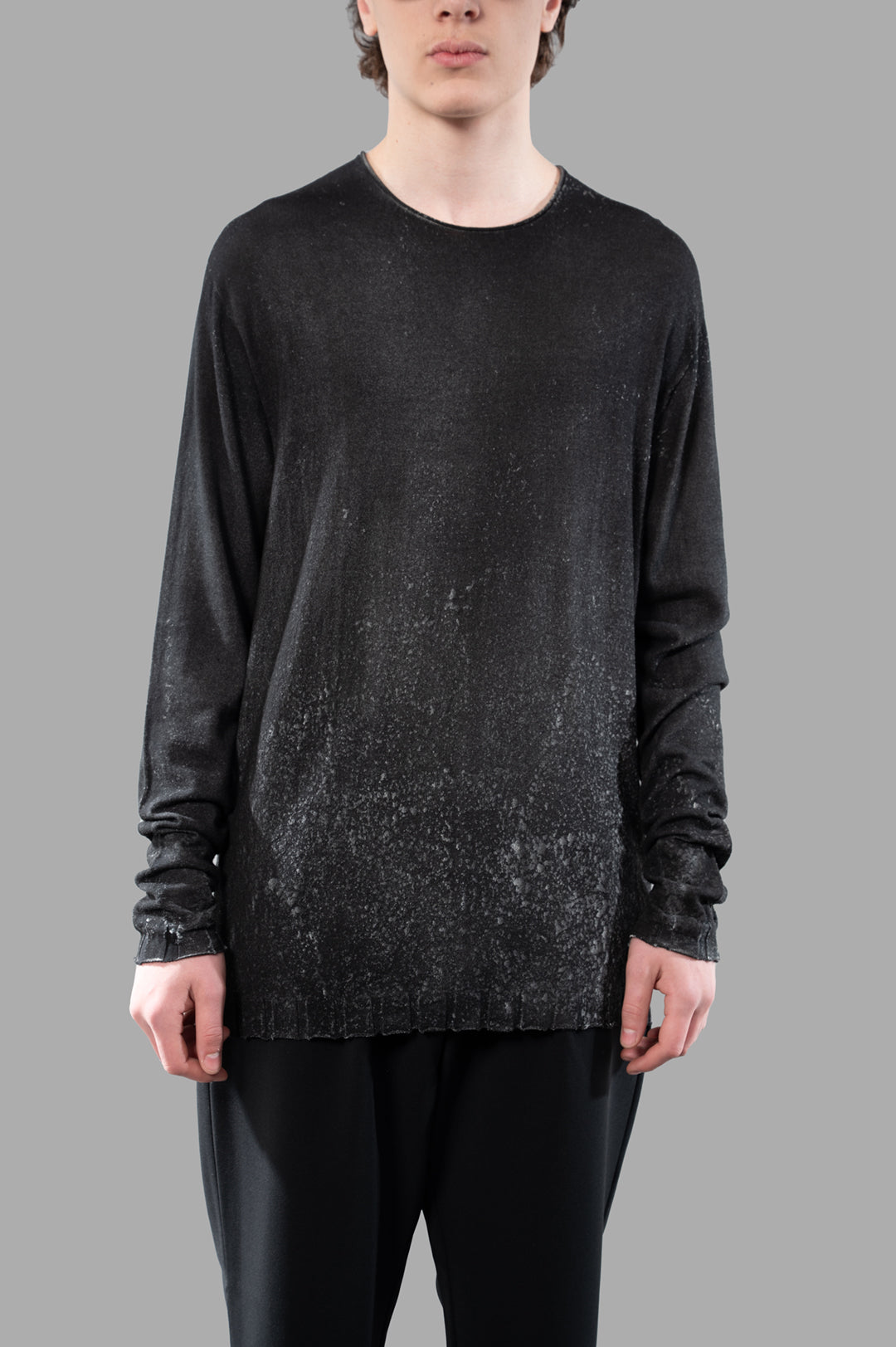 MD 75 Long-sleeved Airbrushed Sweater in black, on-model, showcasing a unique textured design and relaxed-fit silhouette.