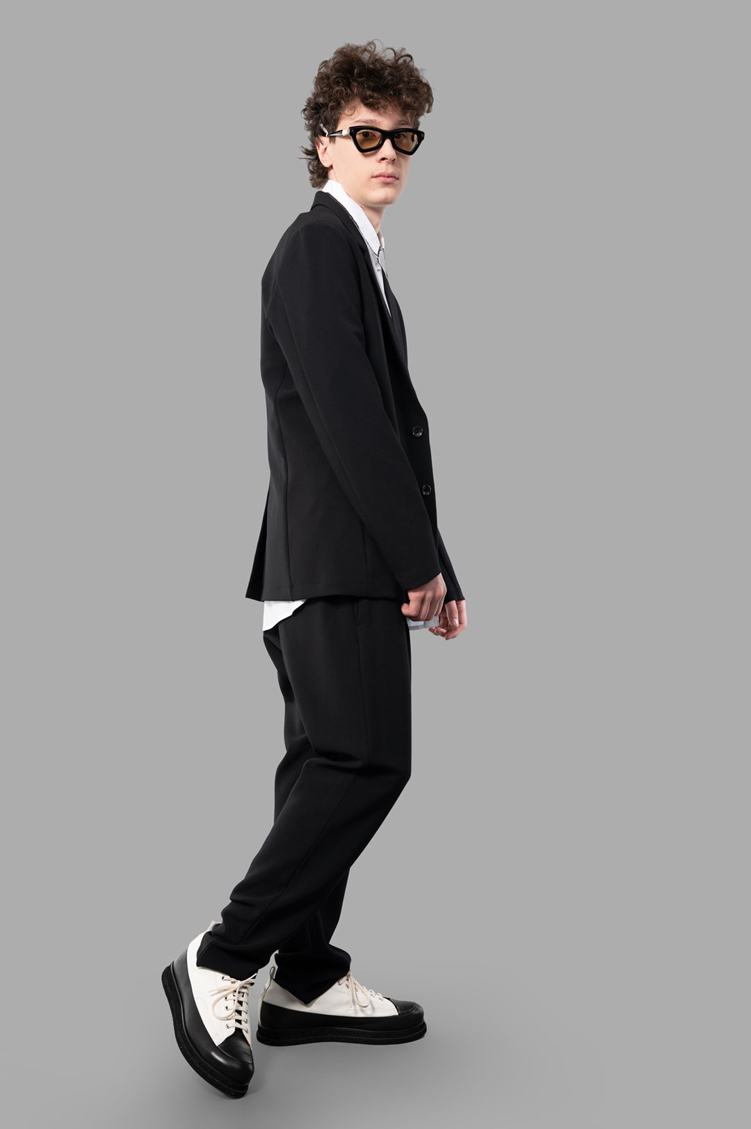 Attachment Single-breasted Blazer in black, side view on-model showing elegant, stretchy wool-like polyester fabric.