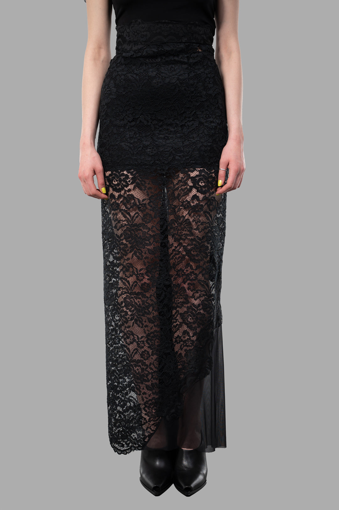 Sehnsucht Atelier Lace Maxi Skirt in black showcases a semi-transparent lace design with floral patterns, worn on a model.