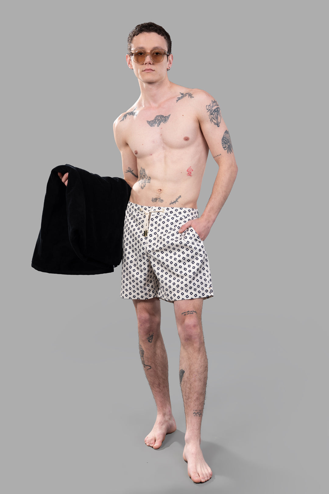 Orlebar Brown Bulldog Drawcord Swim Shorts front view, on-model, with black jacket draped over arm.
