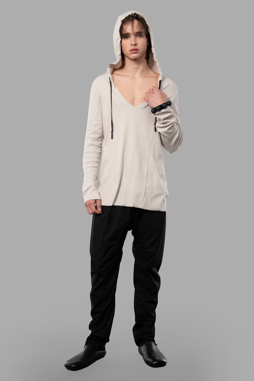 Justin Gall Light Rib Hooded Top in beige, front view on model, features V-neck and waxed drawstring, soft texture.