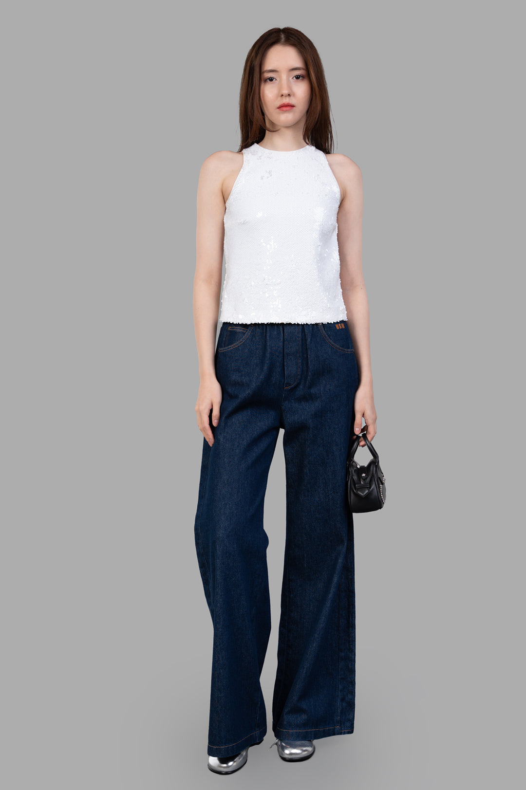 MSGM White Sequin Top on model, showcasing front view with sparkling detail, paired with denim pants.