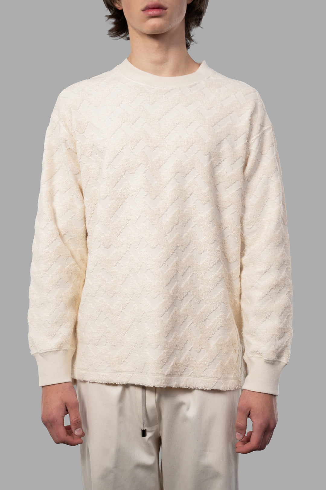 Comme des Garçons Terrycloth Sweater in ecru, featuring textured zigzag design, round neckline, and relaxed fit on model.