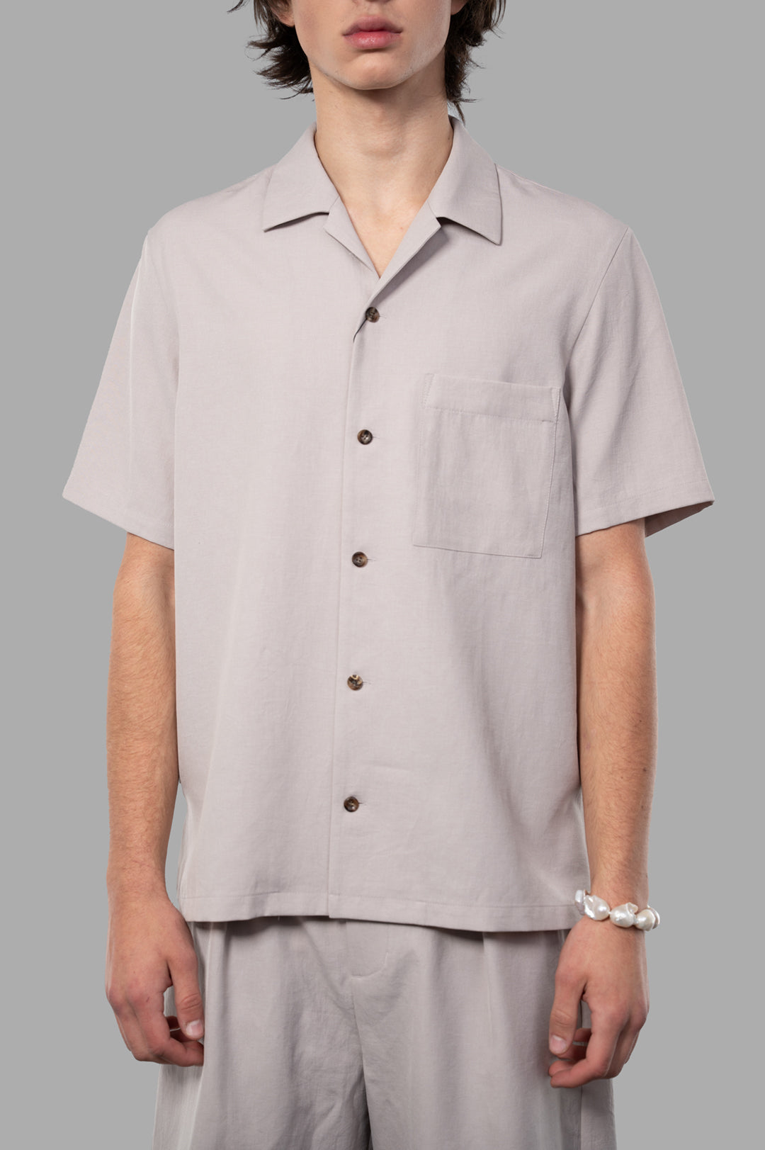 Attachment Regular-collar Shirt in beige with a matte texture, set-in sleeves, and a chest pocket, displayed on a model.