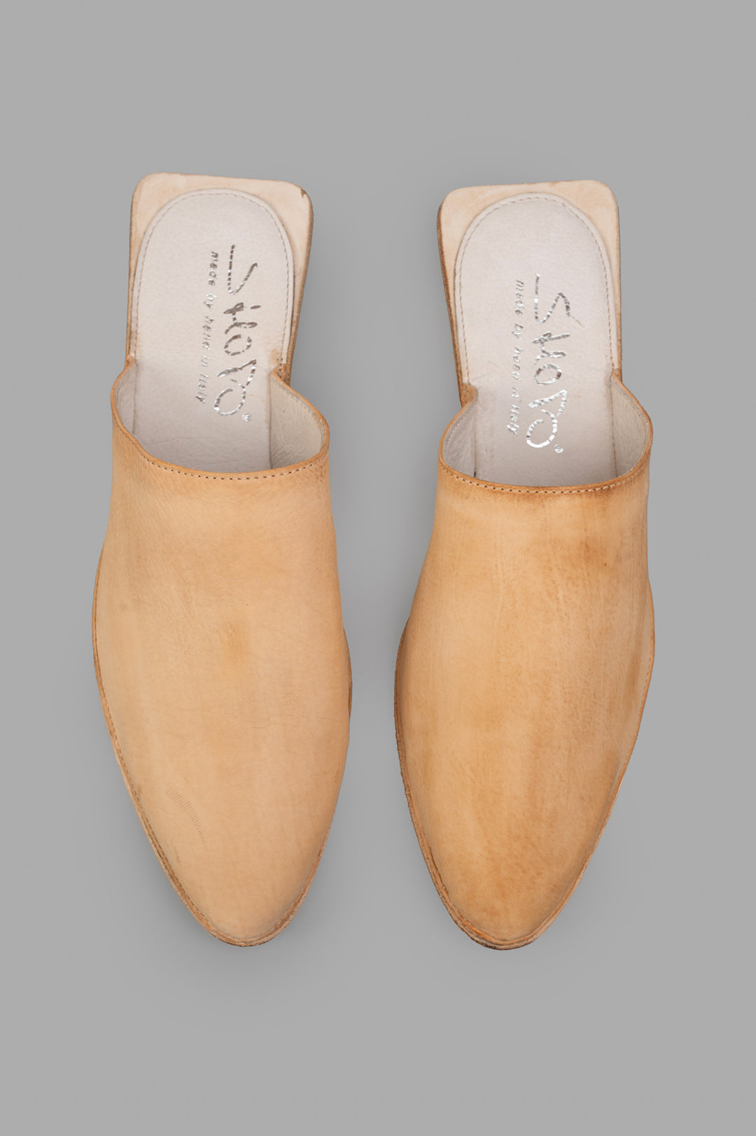 Shoto. Leather Mules in beige, showcasing a smooth leather texture from a top view, highlighting handcrafted details.