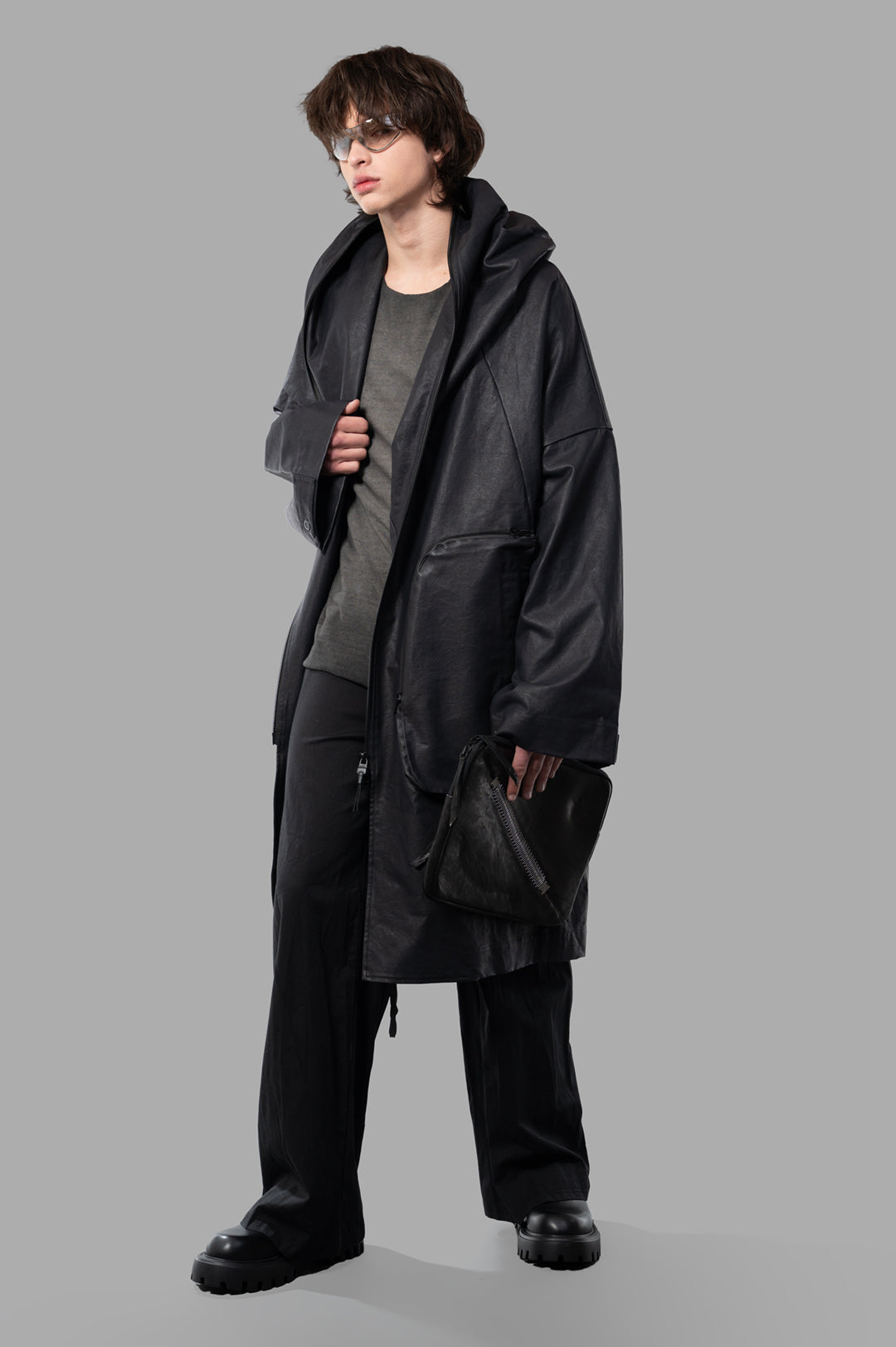 Justin Gall Coated Bodybag Parka, black, front view with shawl hood, large 3D pockets, worn by model in gray top.