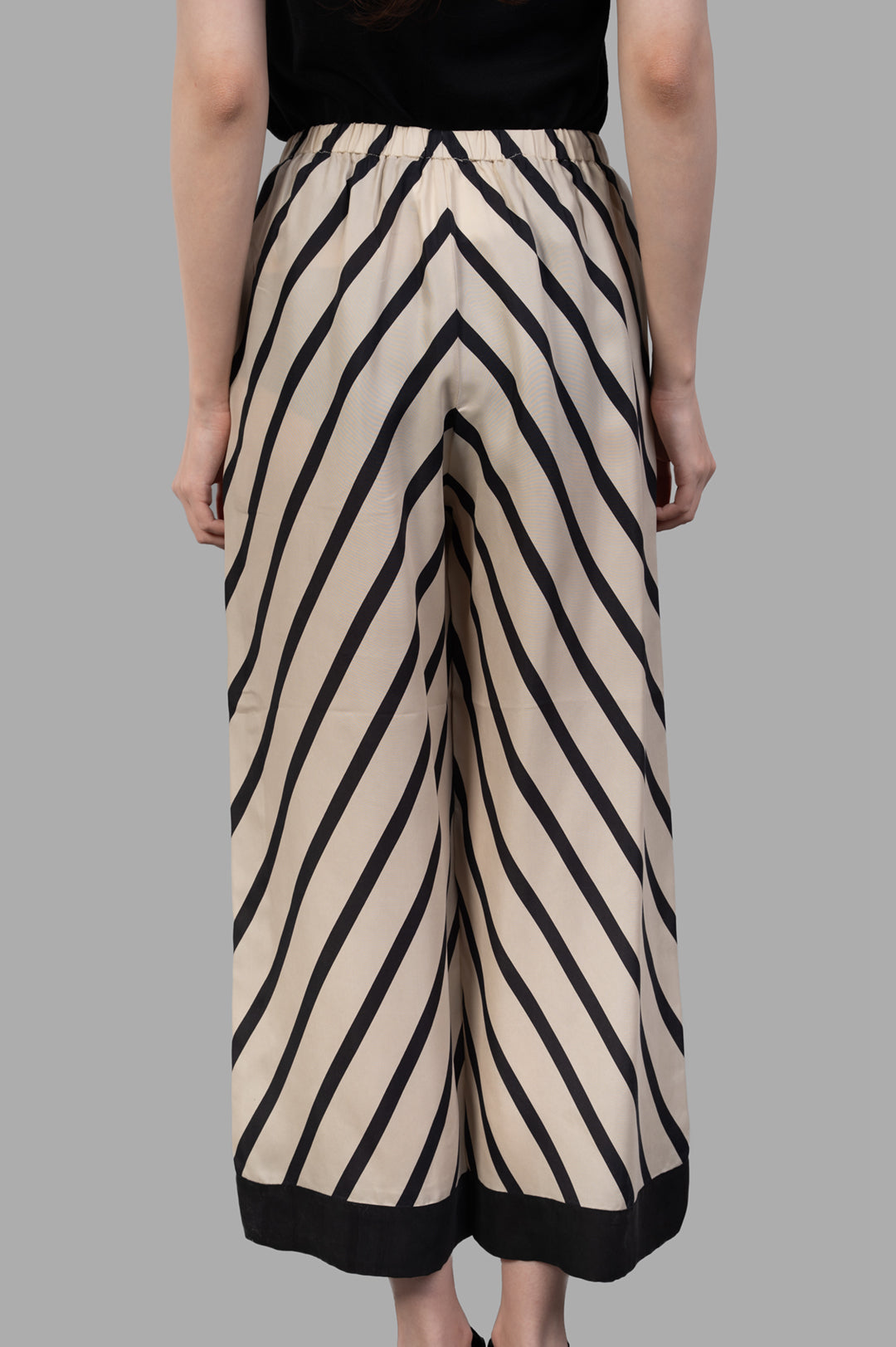 By Malene Birger Mirabello Wide-leg Trousers with side pockets and a relaxed fit, displayed from a side view.