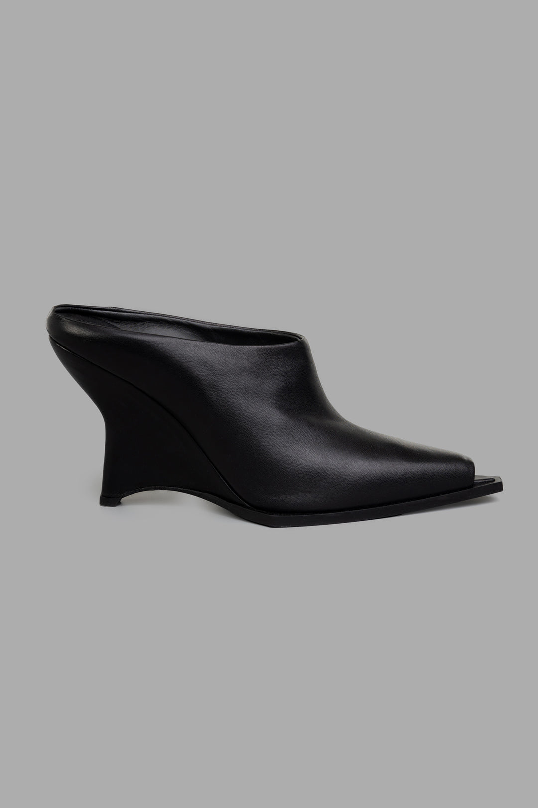 Mattia Capezzani black wedge mules, side view, handcrafted in 100% leather, showcasing sculptural elegance.