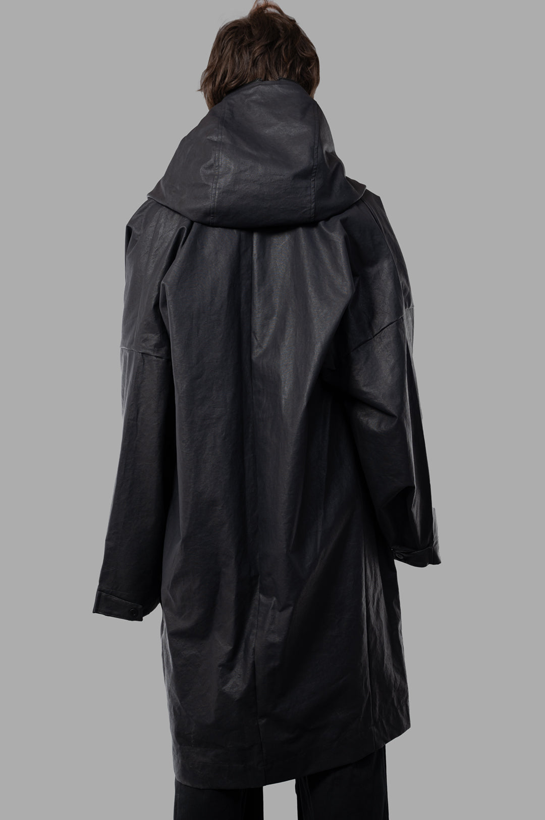 Justin Gall Coated Bodybag Parka shown from the back, featuring a large hood and knee-length design in black.