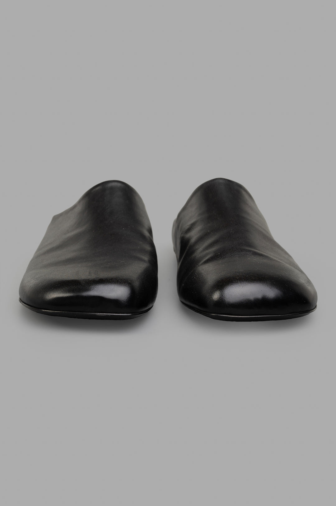 Marsèll Leather Mules displayed from the front, showcasing the smooth black leather and minimalist design.