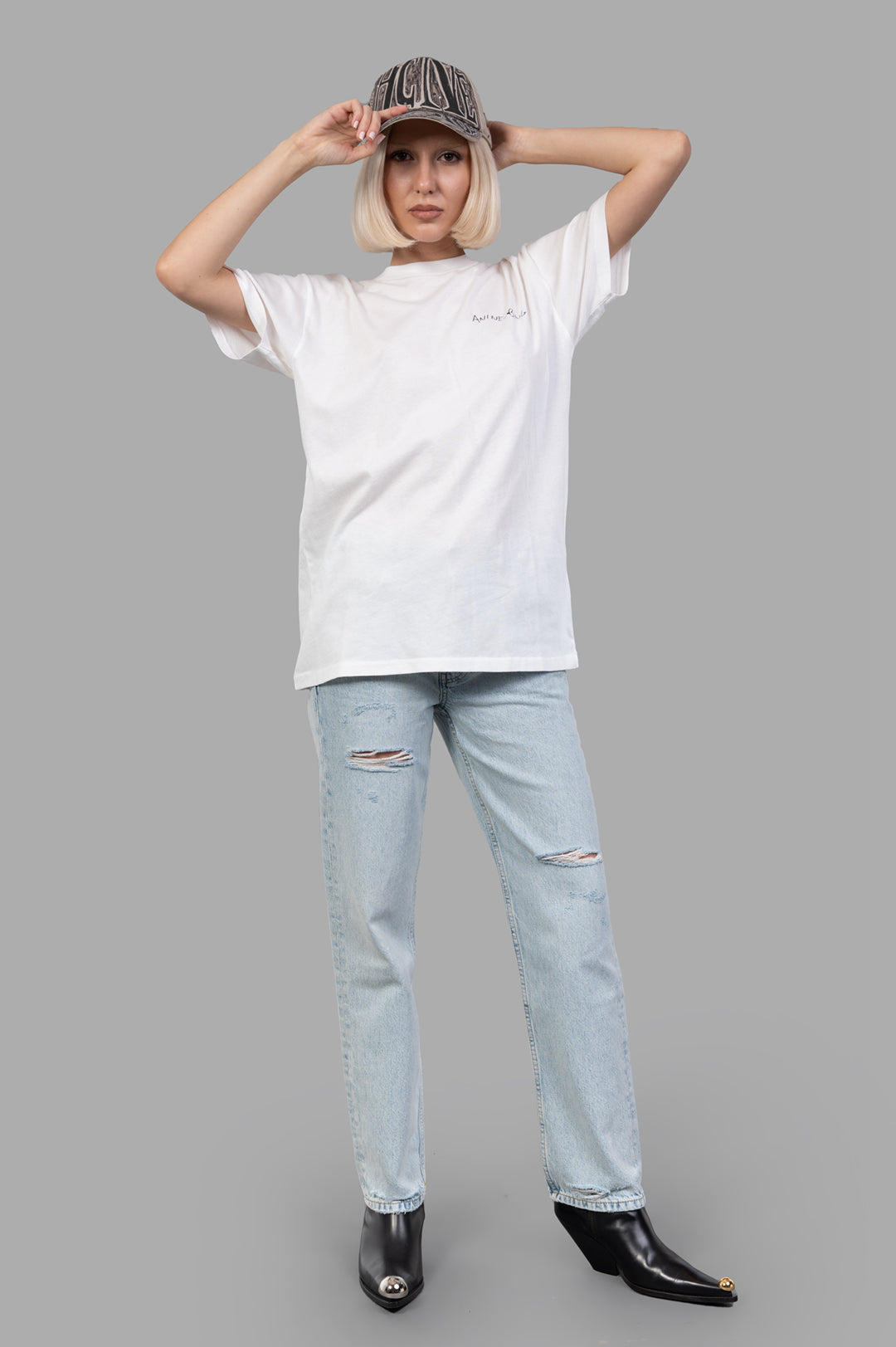 Anine Bing Walker T-shirt with Lyrics in white worn by model, featuring handwritten graphic on front, made of cotton jersey.