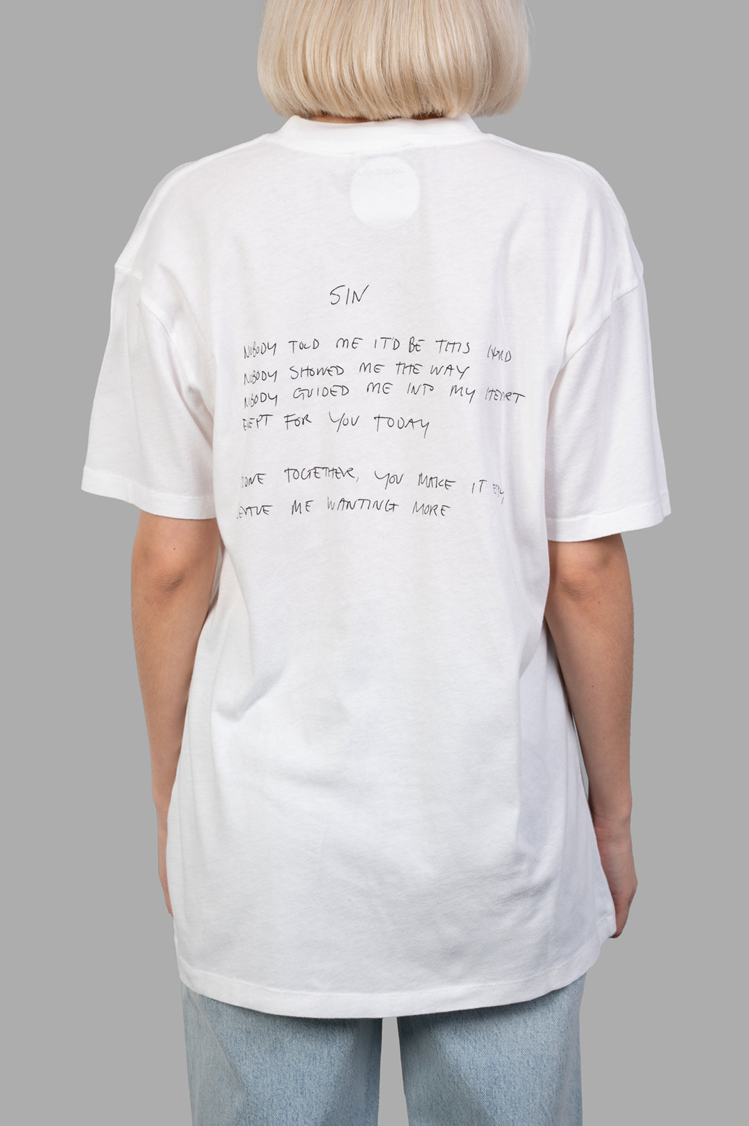 Anine Bing Walker T-shirt with Lyrics featuring handwritten "Sin" lyrics on the back, styled in lightweight ivory cotton.