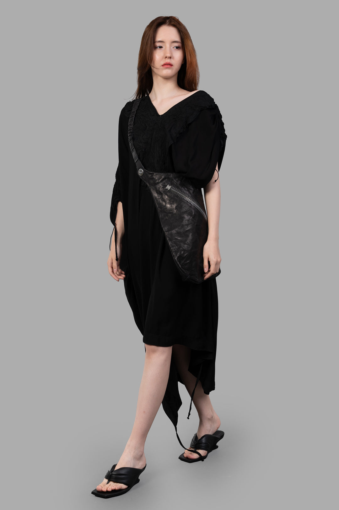 Isaac Sellam Leather-detail Dress on model, showcasing V-neckline, leather accents, cap sleeves, and high-low hem in black.
