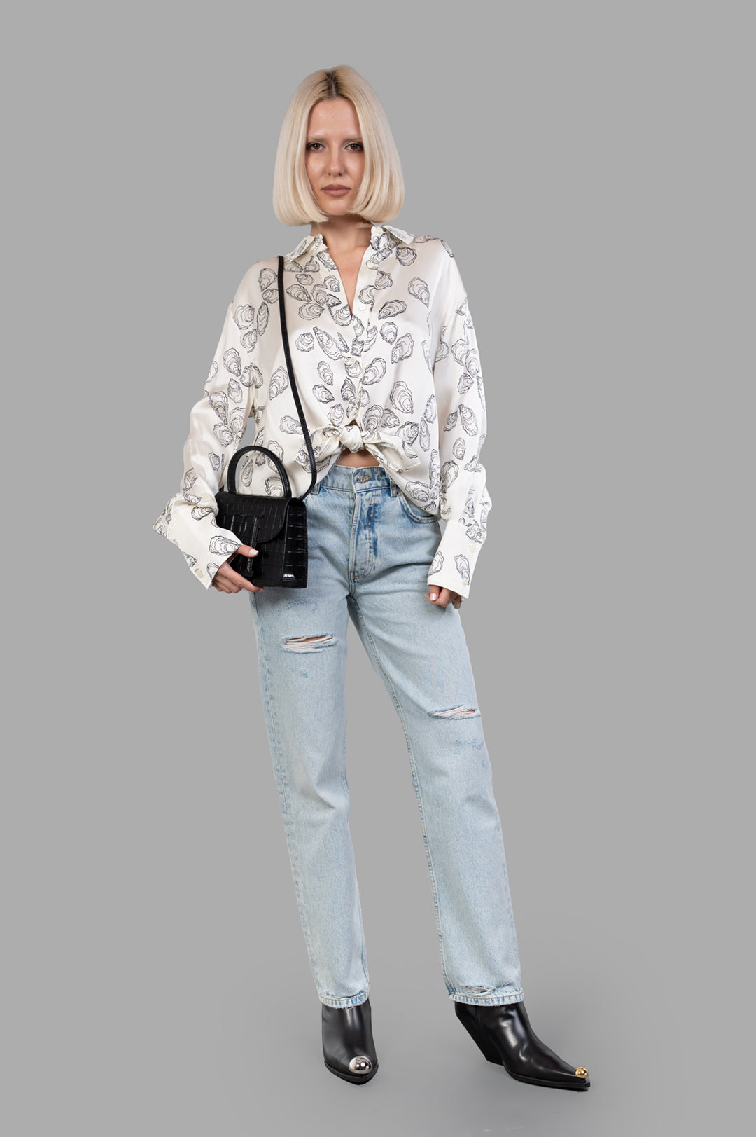 Anine Bing Kate Jeans in distressed blue on model, showcasing rigid cotton denim with vintage-inspired hand sanding.