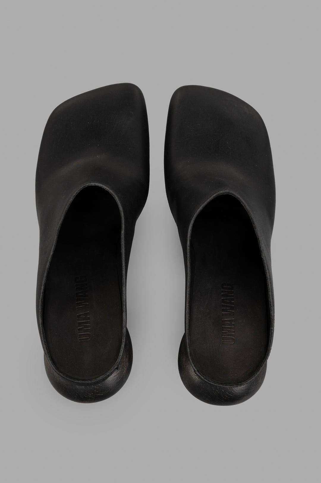 Uma Wang Stone Mules in Black, stylish square toe design and branded footbed, showcasing top view and sleek calf leather.