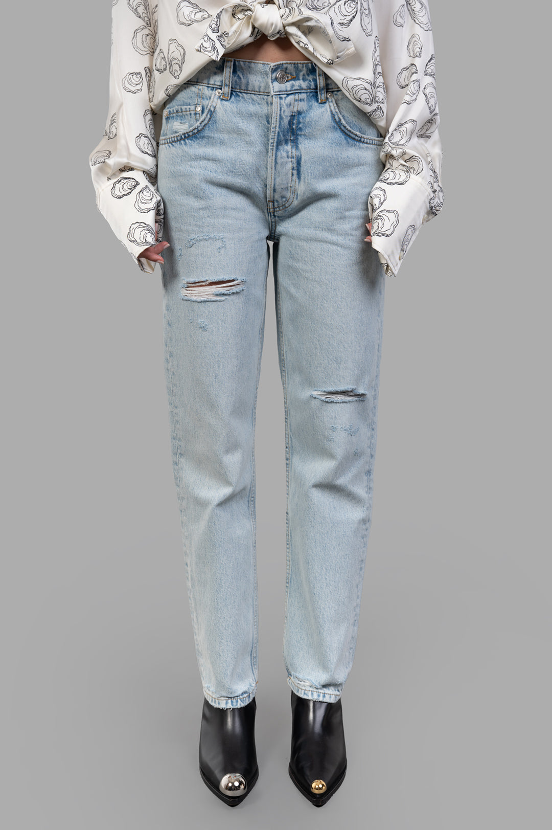 Anine Bing Kate Jeans featured on a model, showcasing a destructed bleached blue wash with stylish rips and vintage details.