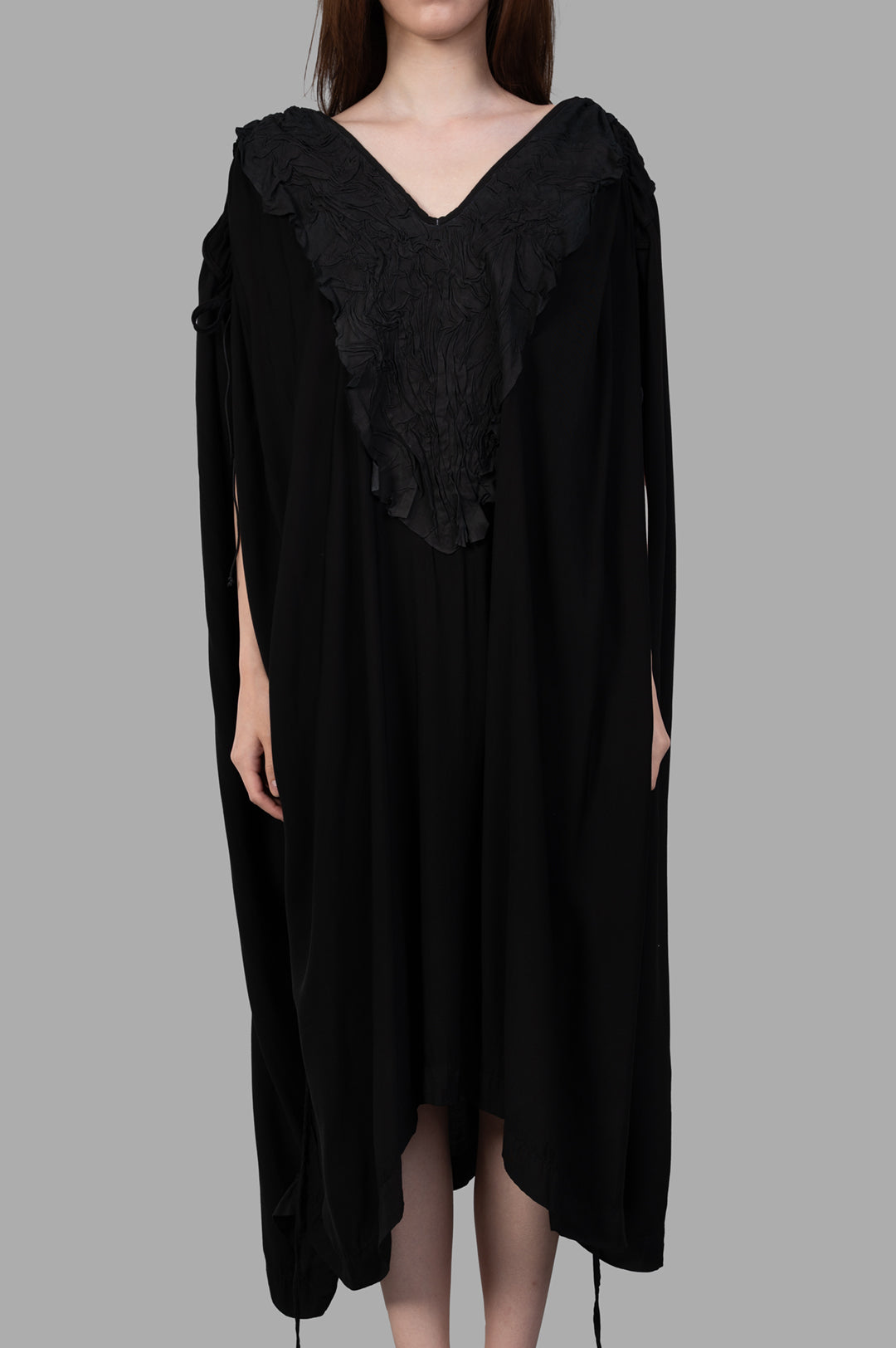 Isaac Sellam Leather-detail Dress featuring a striking V-neckline and elegant structure, worn by a model.