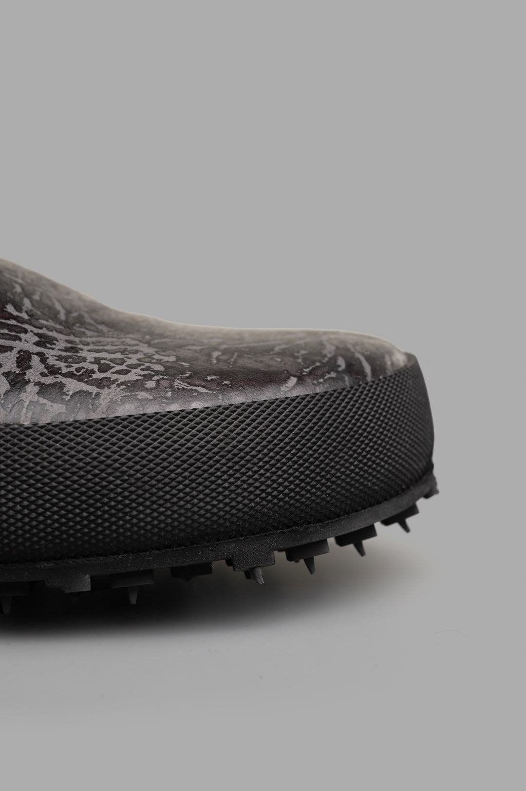 Shoto Slip-on Mules featuring a textured black leather upper and unique dye details for a distinctive look.