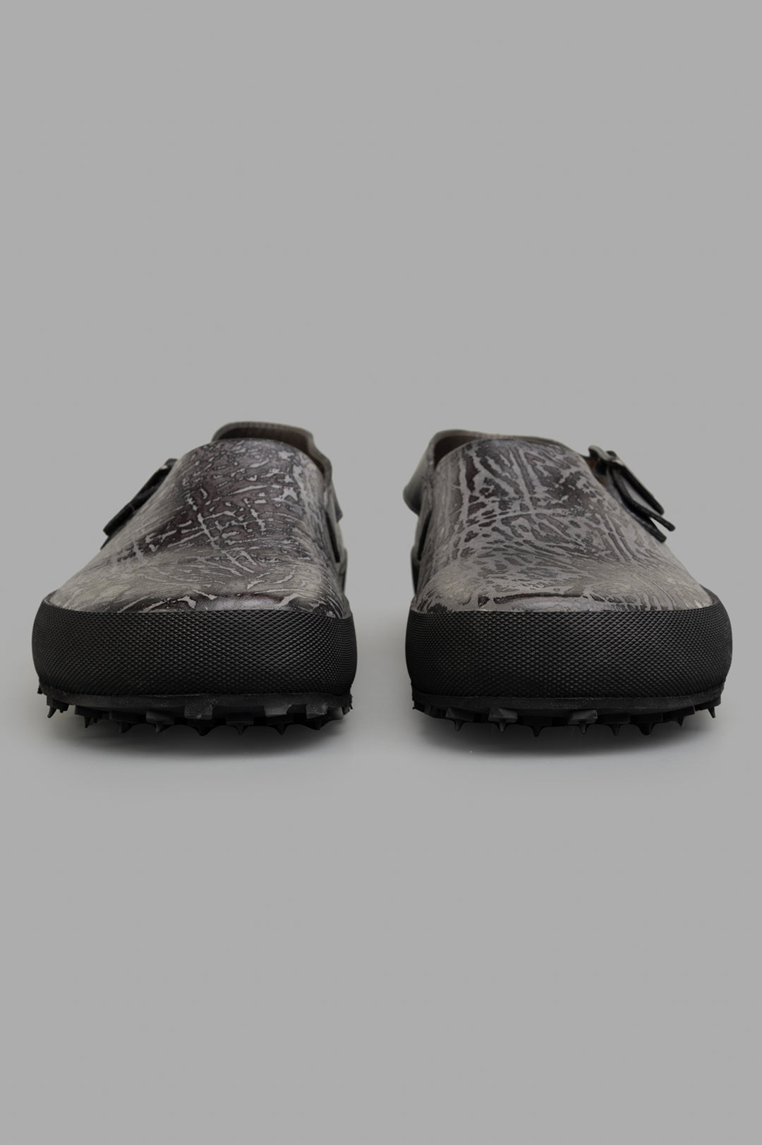 Shoto. Handmade black slip-on mules showcasing unique leather texture and artisanal design, featuring a sturdy sole.