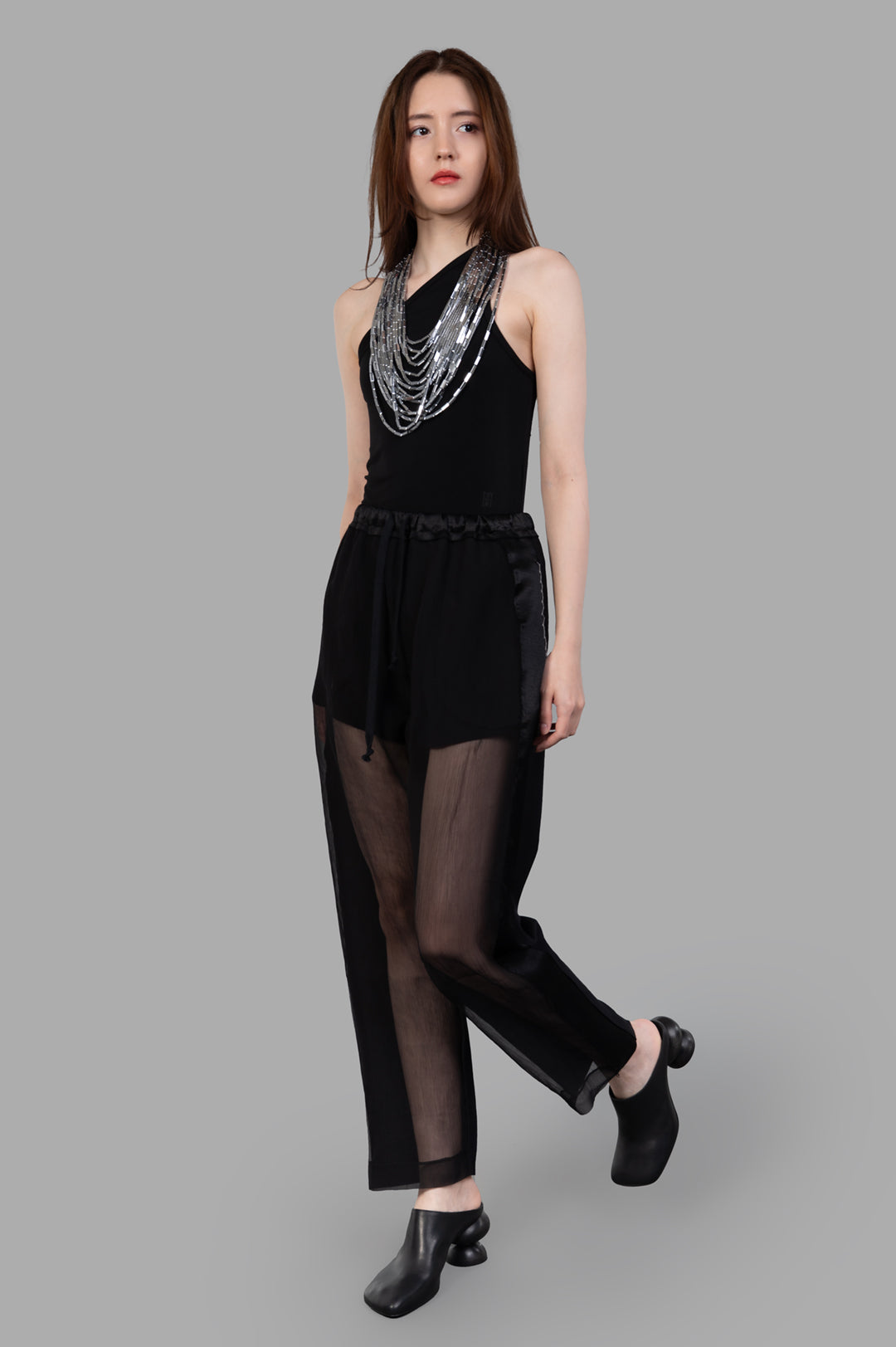 Giovanni Cavagna semi-sheer pants in black silk, front view on model, showcasing elegant and innovative design.