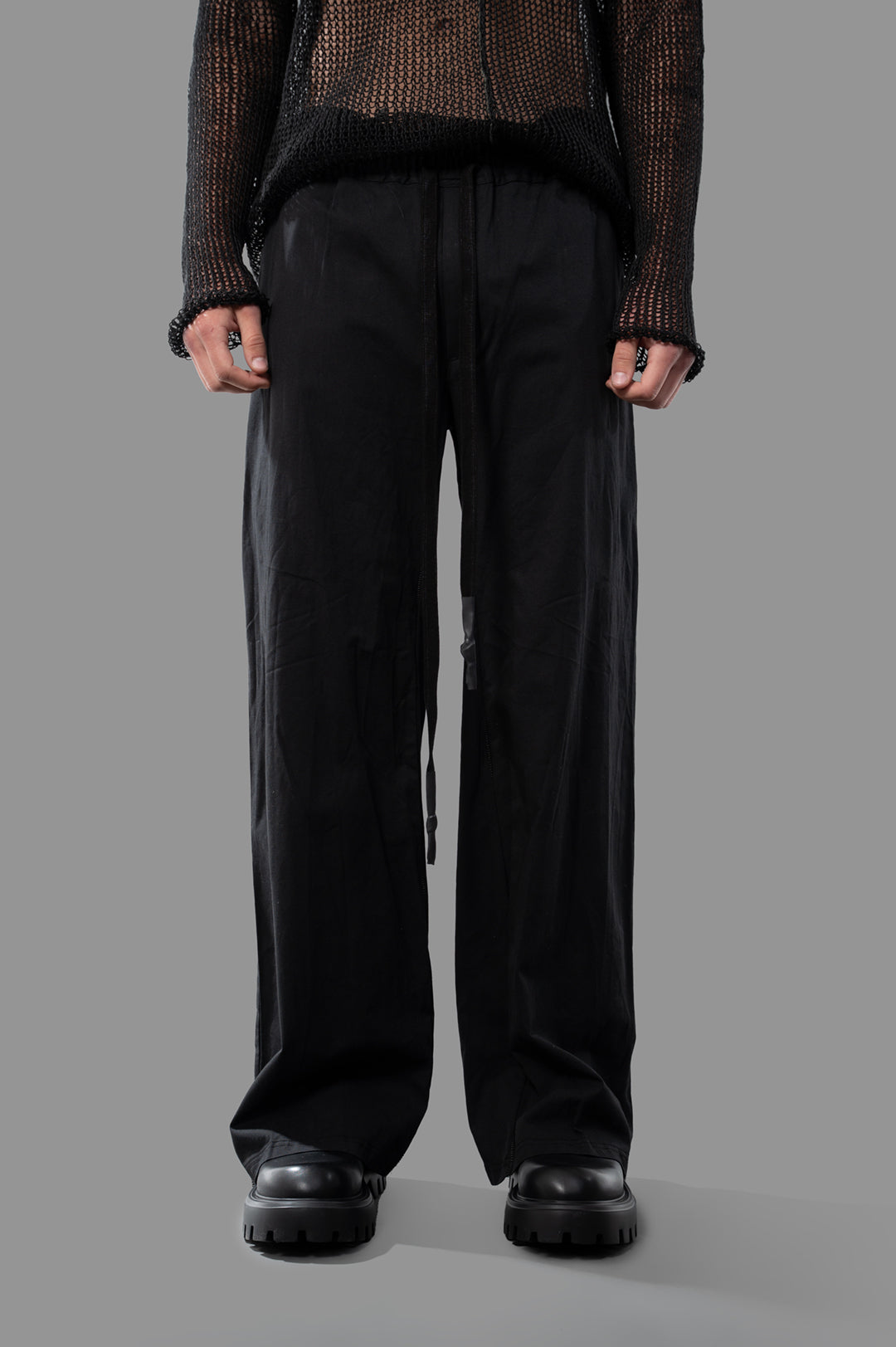 Isaac Sellam Wide-leg Trousers in black, featuring a relaxed fit and drawstring waist, showcased on a model.