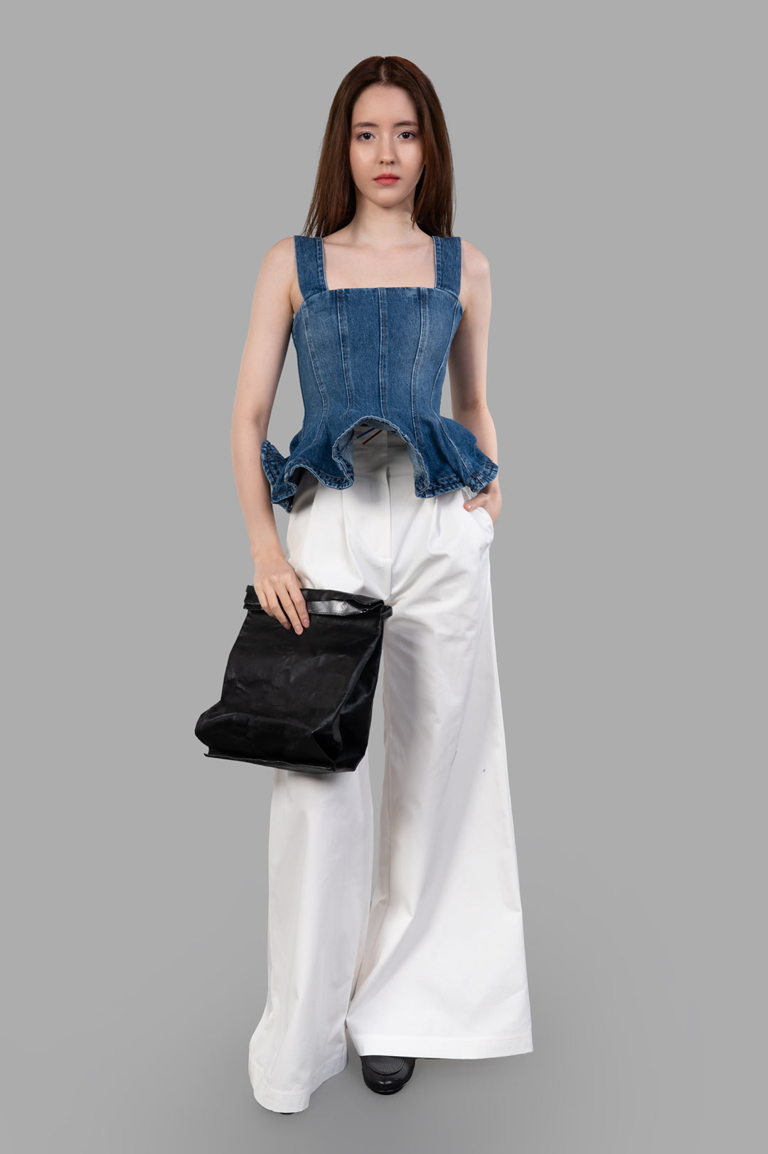 MSGM Denim Peplum Top on model, featuring square neckline and ruffled hem, paired with white wide-leg trousers.