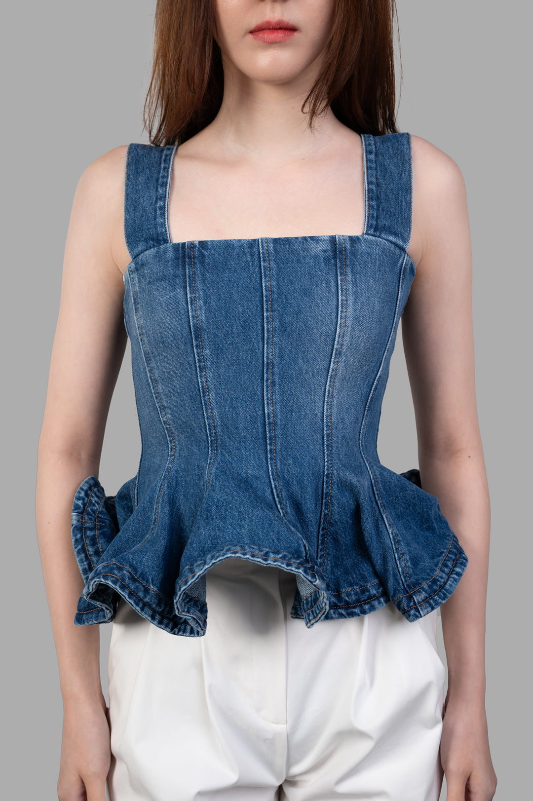 MSGM Denim Peplum Top in blue, featuring a square neckline and ruffled hem. Shows front view, highlighting exquisite details.