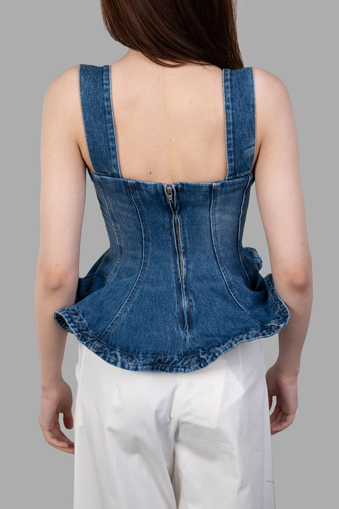 MSGM Denim Peplum Top in blue, showcasing the back view with stylish square neckline and ruffled hem detail.