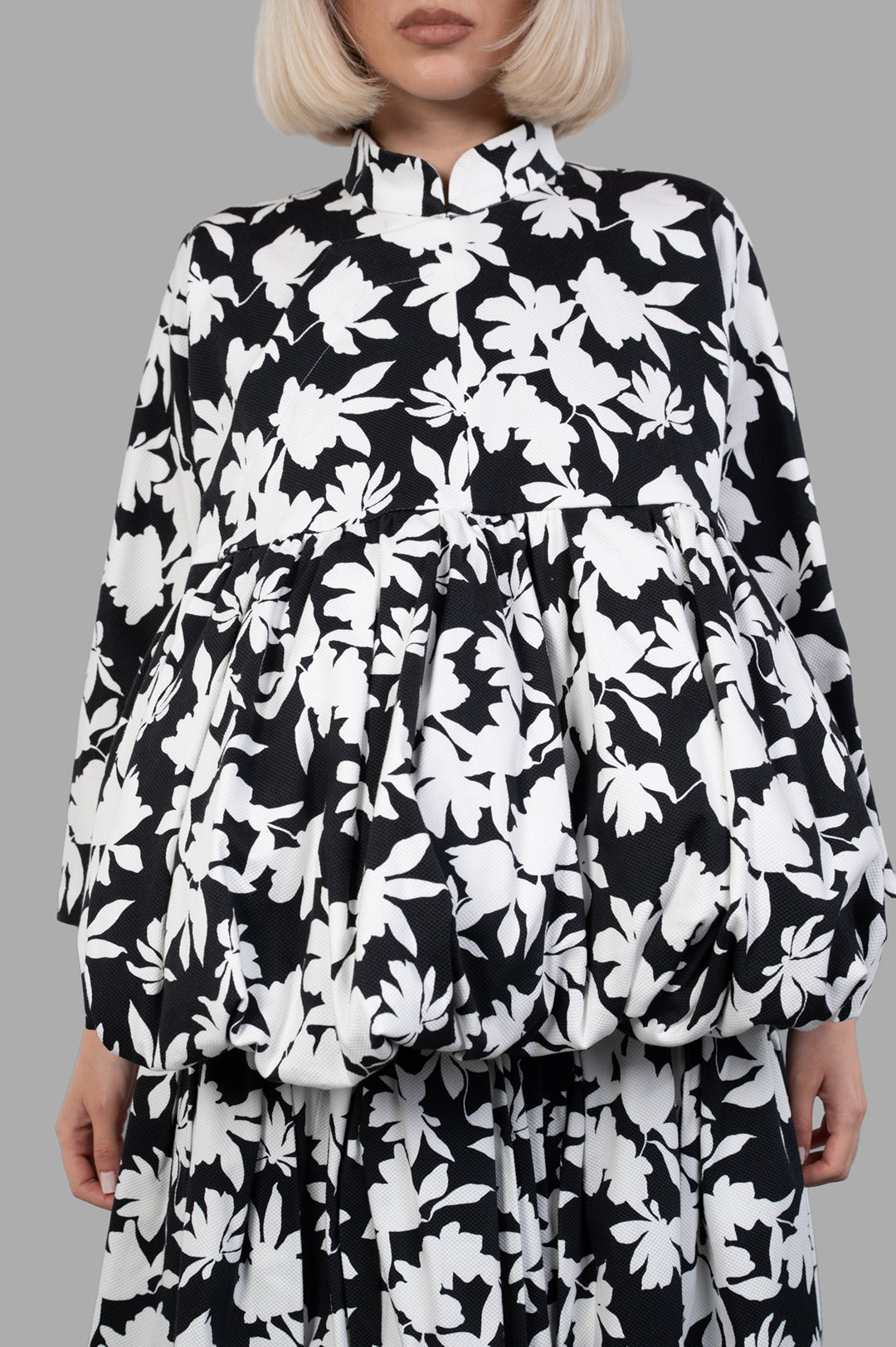 Comme des Garçons Floral-print Pleated Jacket featuring a stand collar and loose fit, showcasing black and white floral design.