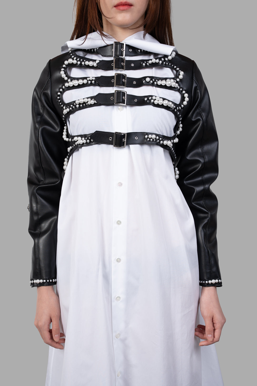 Noir Kei Ninomiya Pearl-Detailed Jacket showcasing front view with pearl embellishments and adjustable straps on a model.