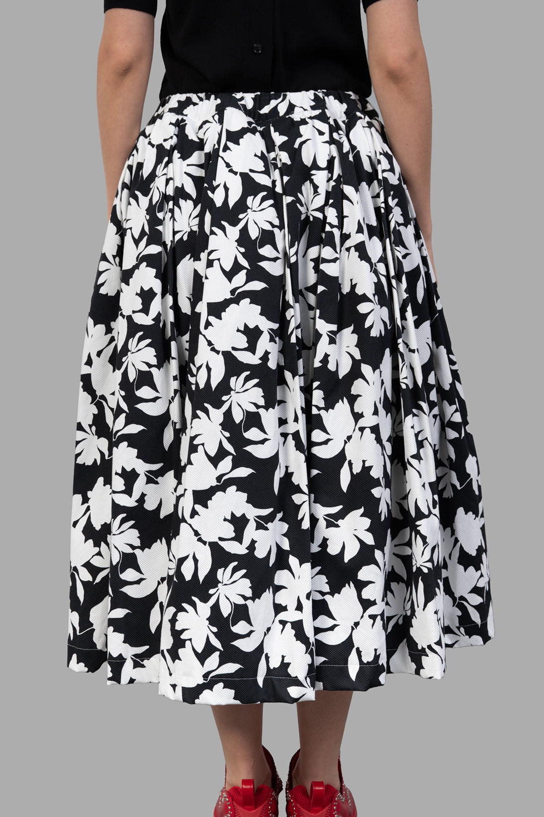 Comme des Garçons Floral-print Skirt showcasing a black and white floral design, with side pockets and tulle lining on model.