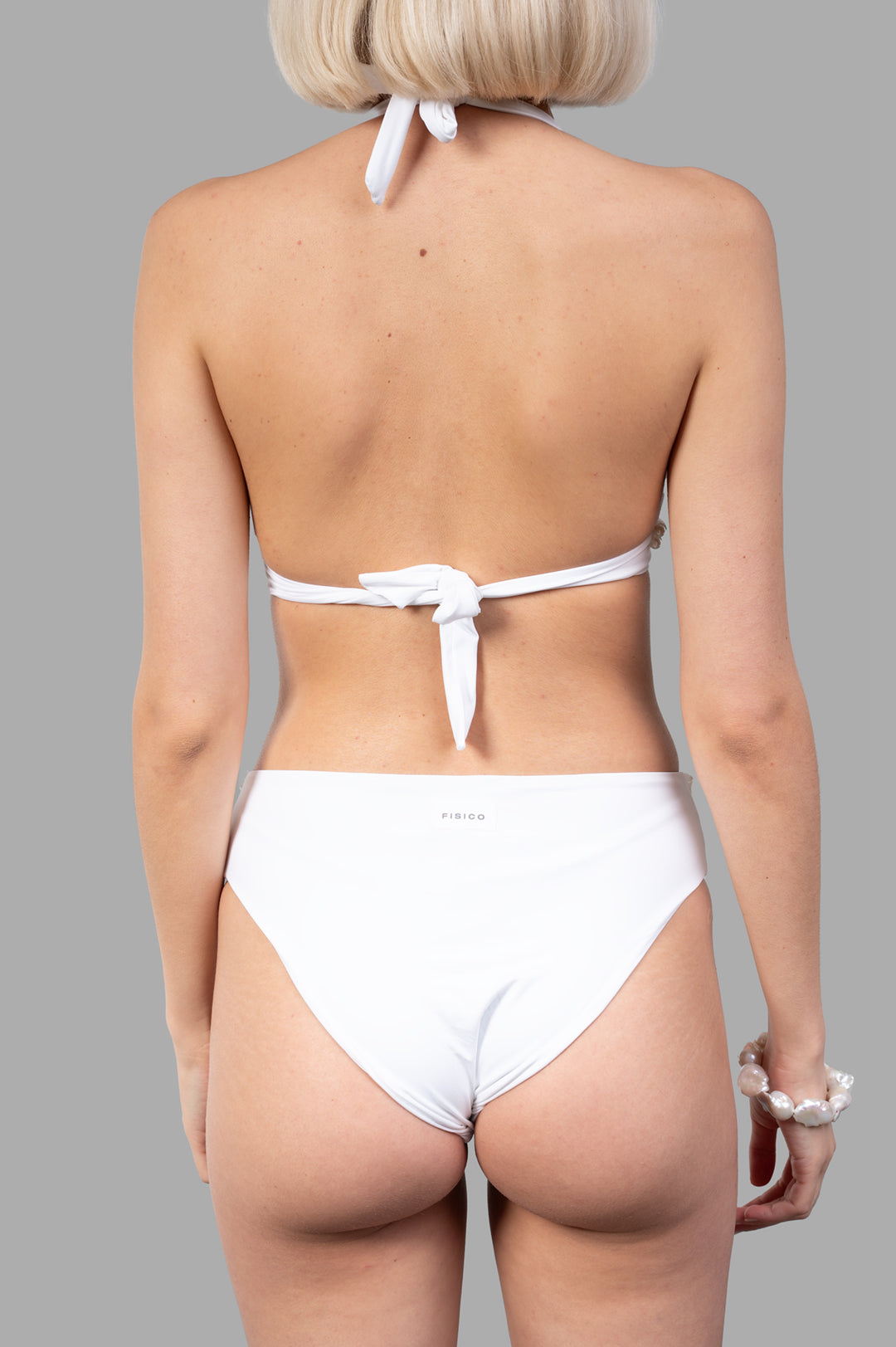 Fisico Pearl Bikini Set shown from the back, featuring a tie detail on the halter neck and luxurious white fabric.