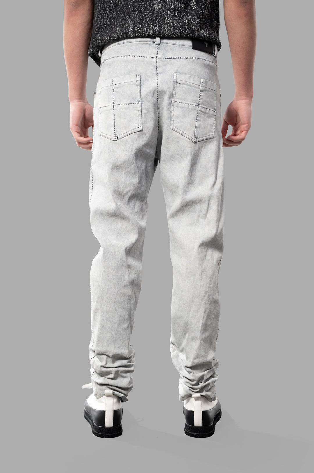 MD 75 Coated Jeans in white, featuring a back view showcasing architectural details and relaxed fit. Ideal for stylish comfort.