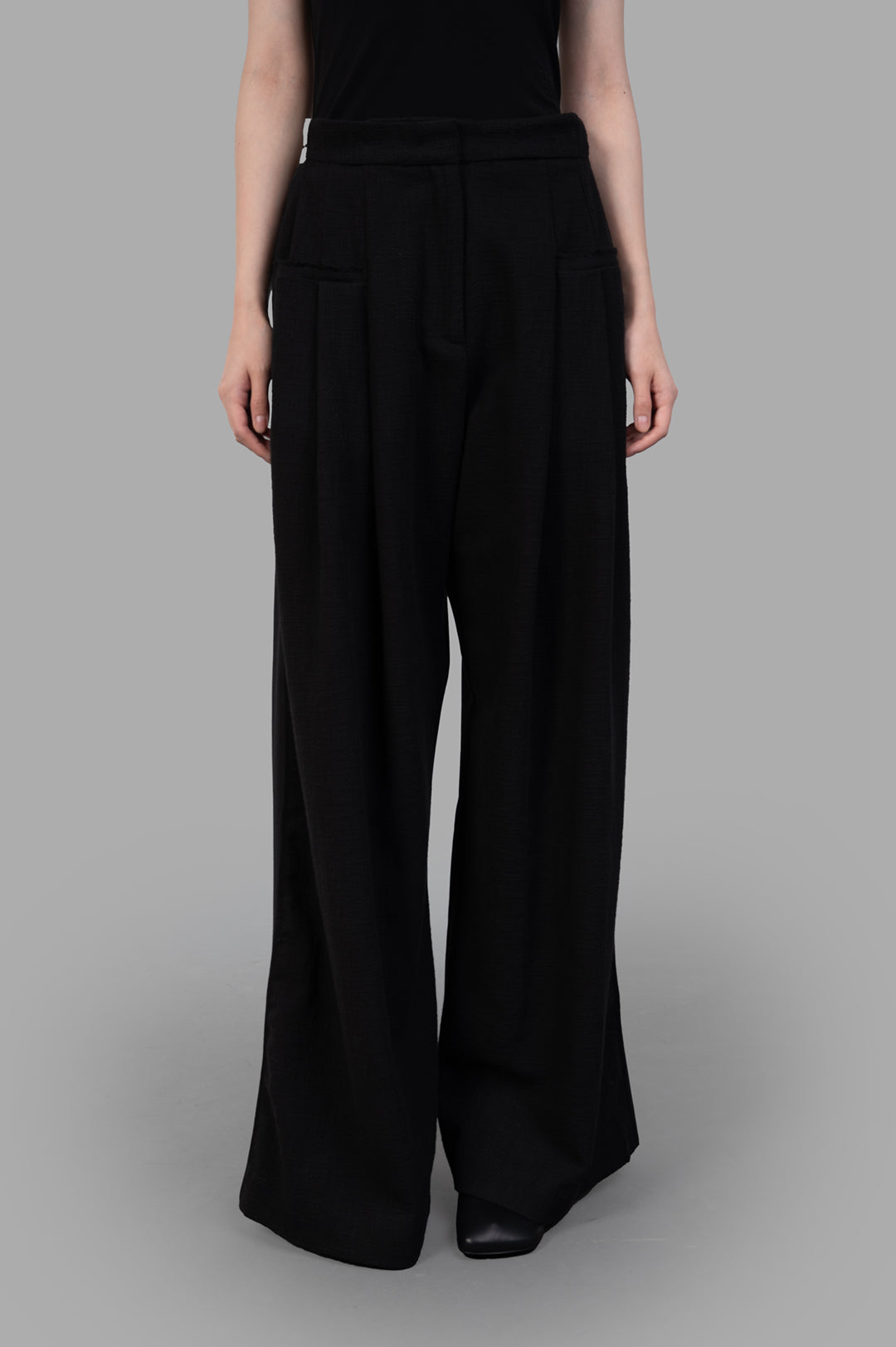 Giovanni Cavagna Wide-leg Trousers showcasing a relaxed fit with front pockets, made from soft black linen fabric.