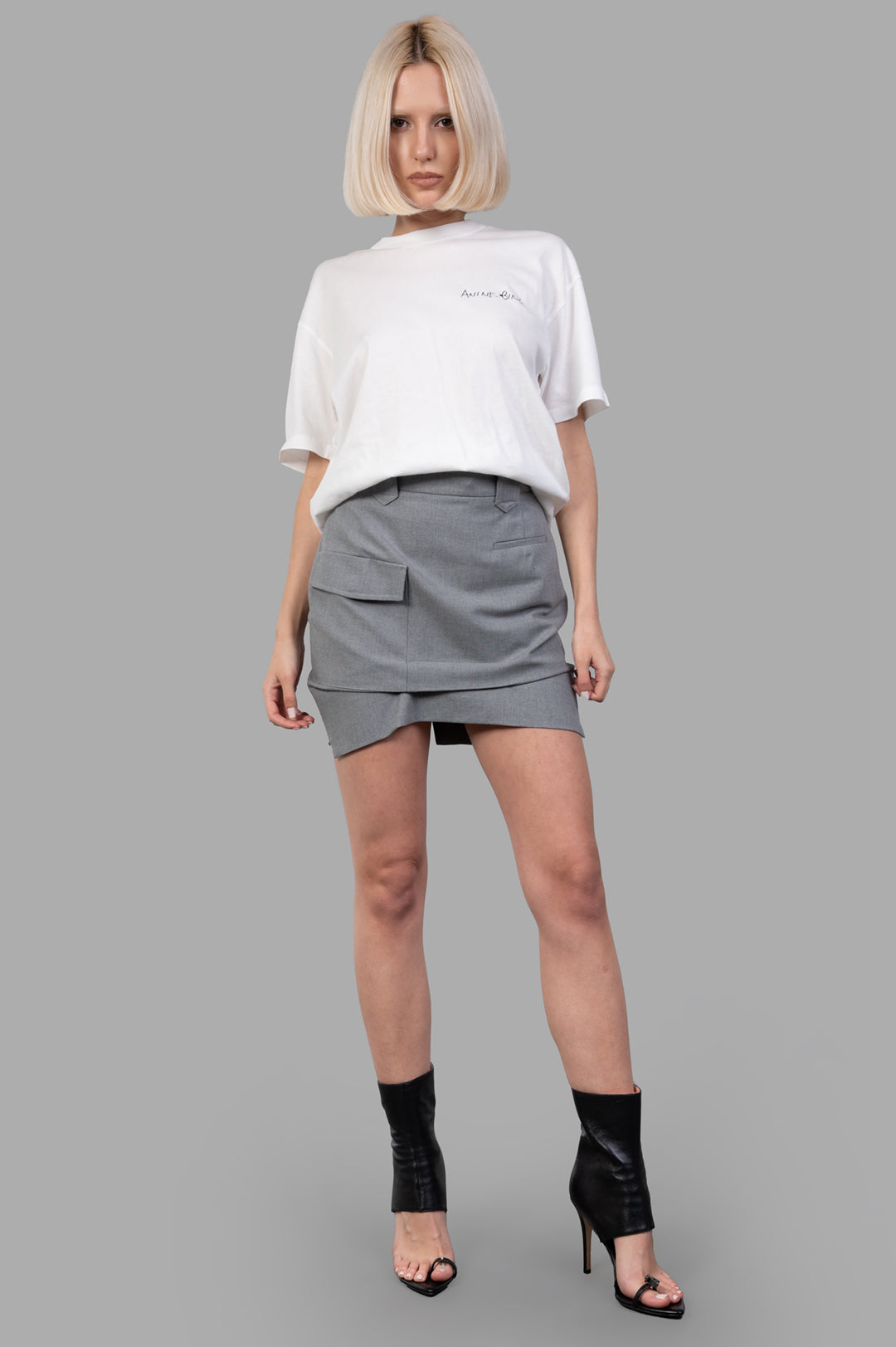 Vivienne Westwood grey Pleated Cargo Mini Skirt front view on model, featuring front button and zip, cotton fabric.