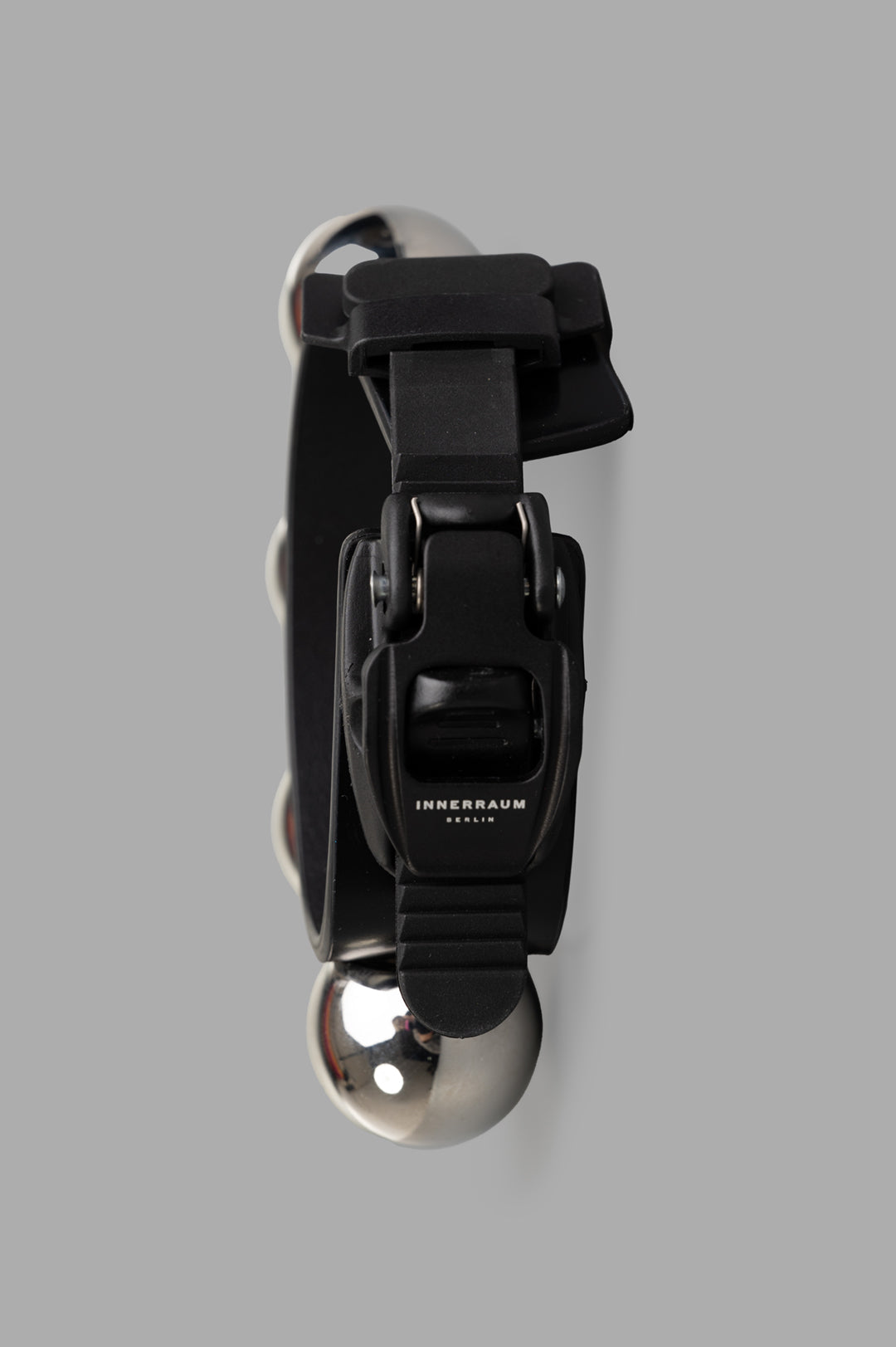 Innerraum Silver Stud Bracelet featuring a bold design with shiny silver beads and adjustable black strap, viewed from above.