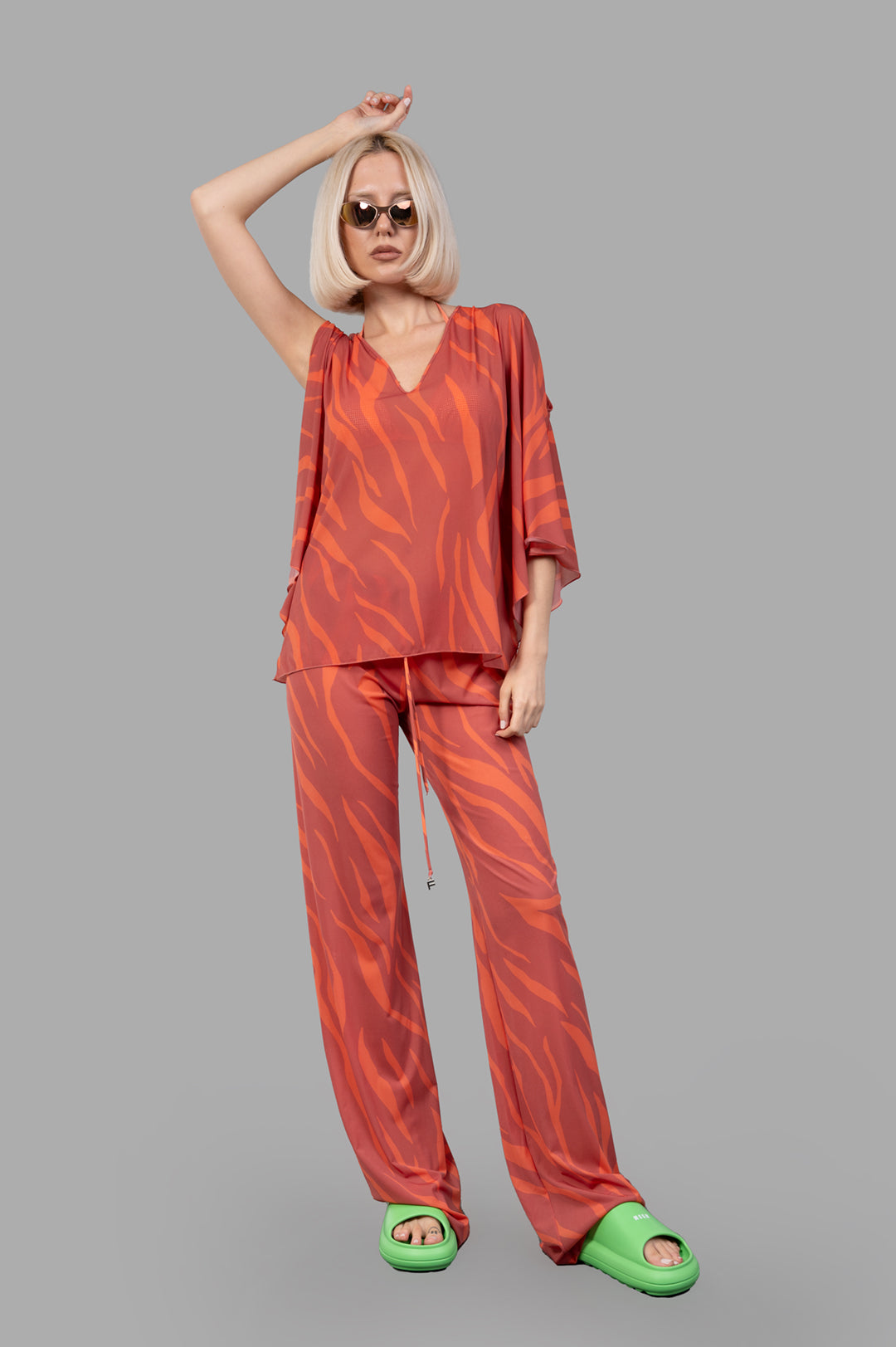 Fisico Zebra-print Top in coral with flowing sleeves, front view on model, showcasing bold, luxurious fabric style.