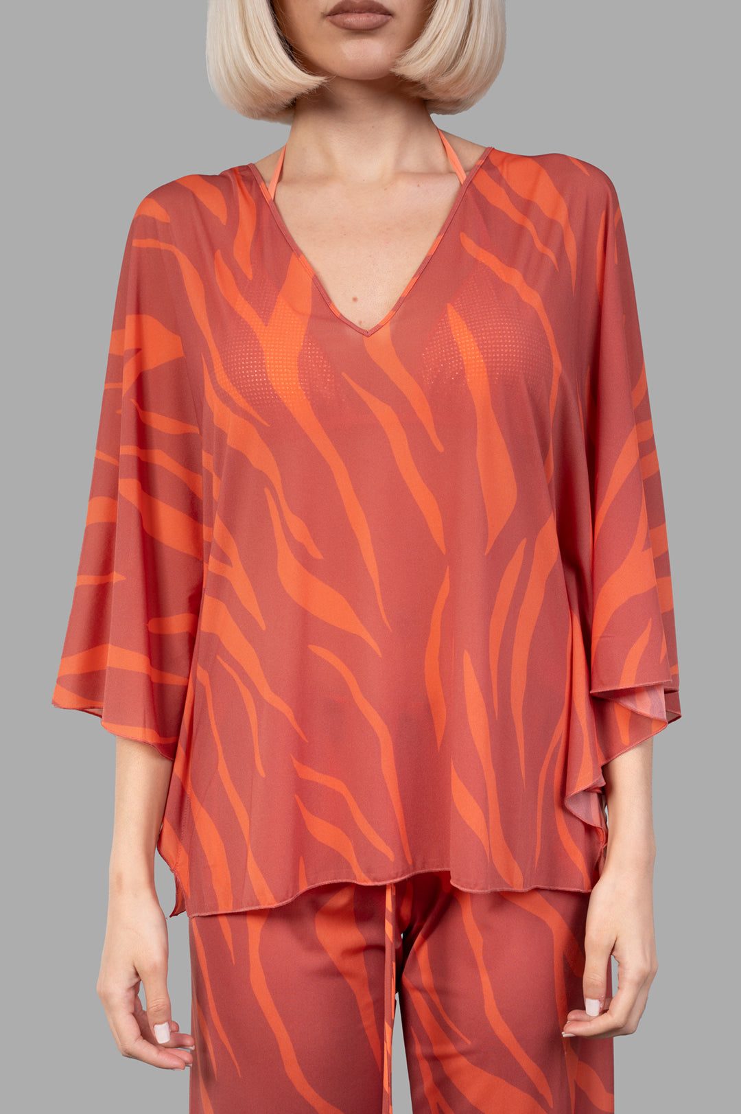 Fisico Zebra-print Top in coral, showcasing a flowing design with a flattering V-neck on a model, perfect for summer.