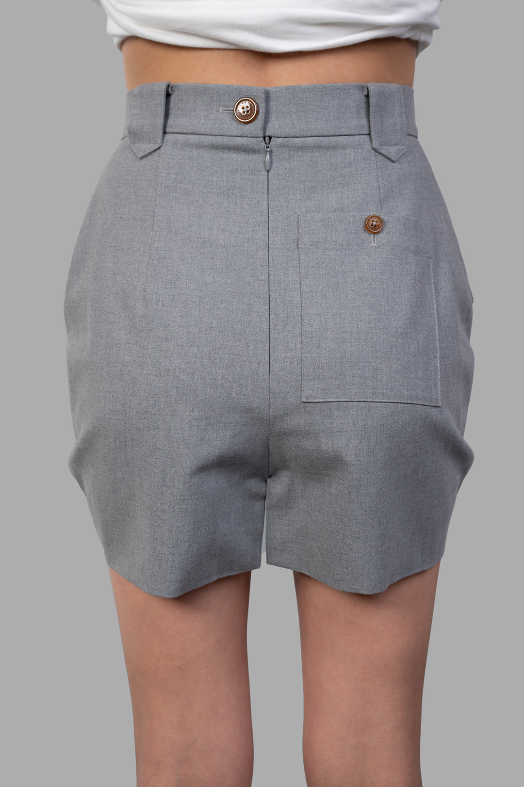 Vivienne Westwood Pleated Cargo Mini Skirt showcased from the back, featuring button and zip closure, grey cotton fabric.