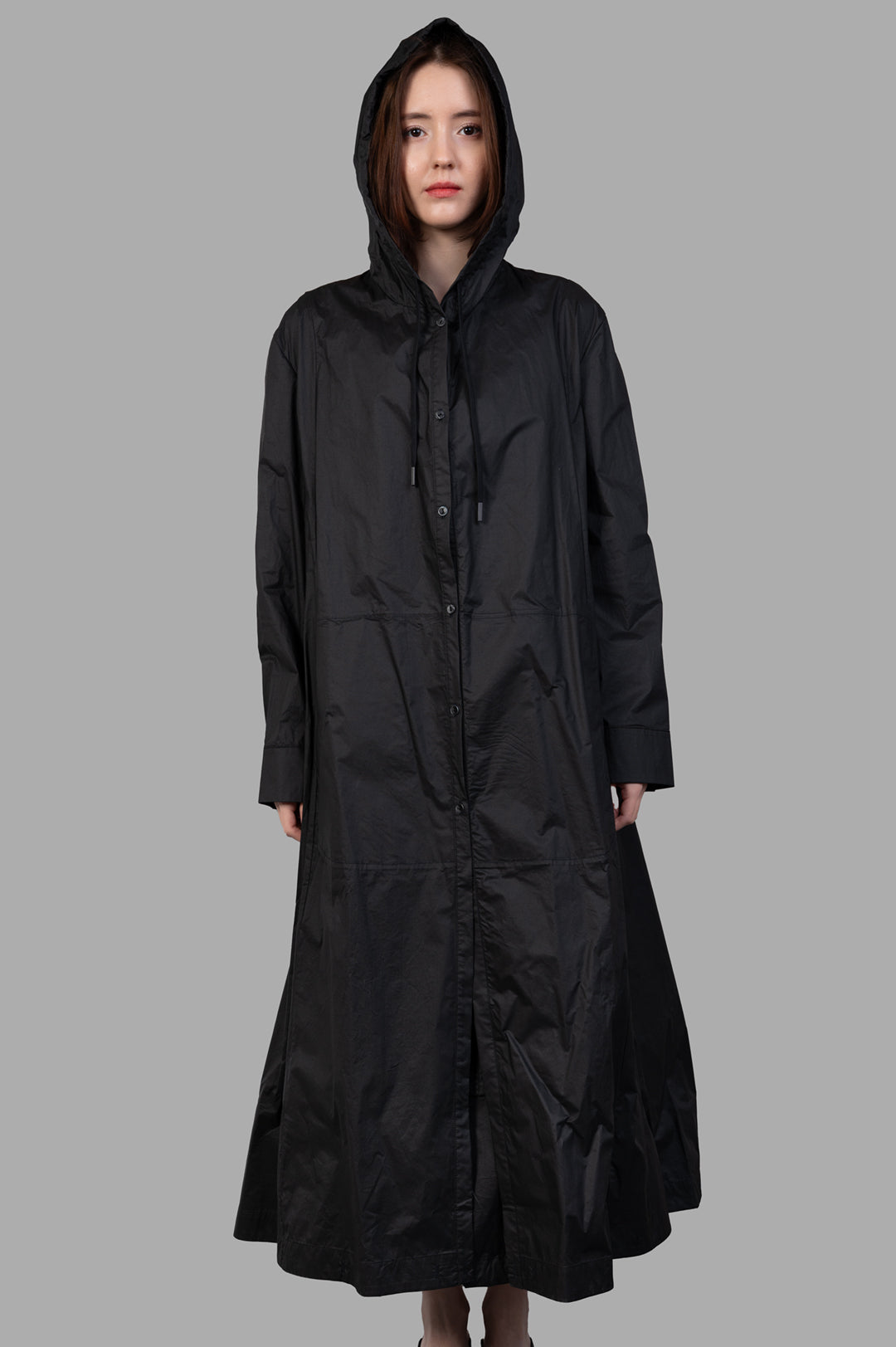 Masnada 2-in-1 Parka, black hooded long coat, front view on-model, button-front with drawstrings.