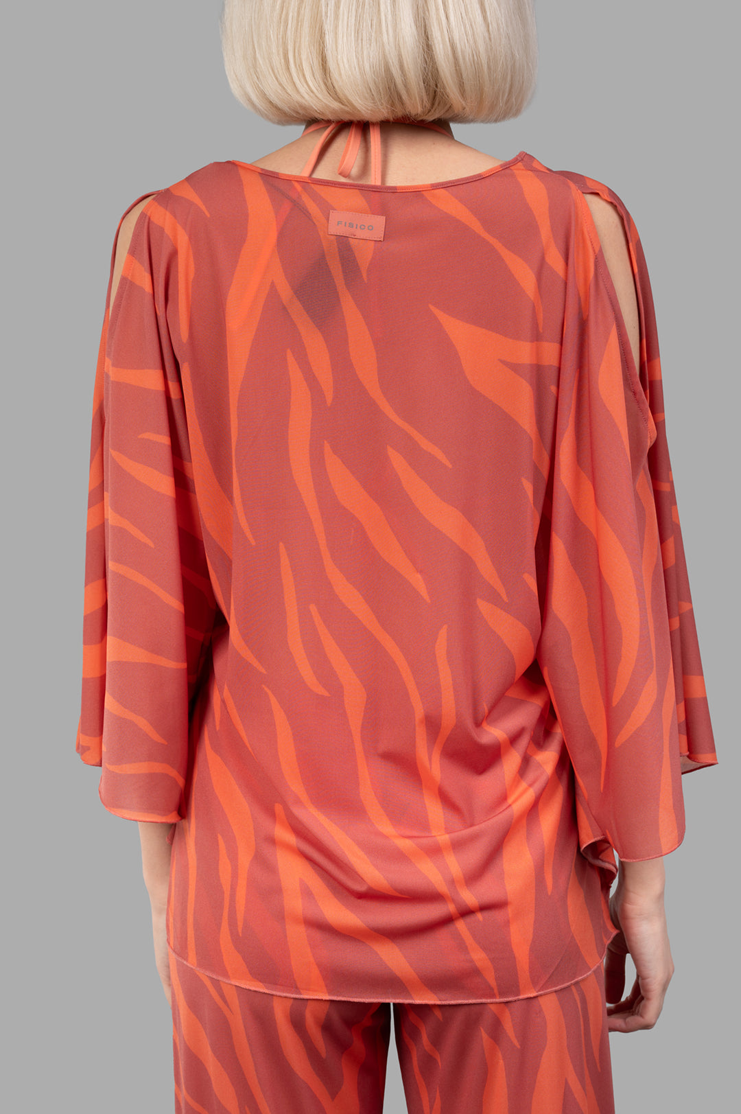 Fisico Zebra-print Top featuring a vibrant coral design, showcasing a stylish back view with elegant draping and cut-out.